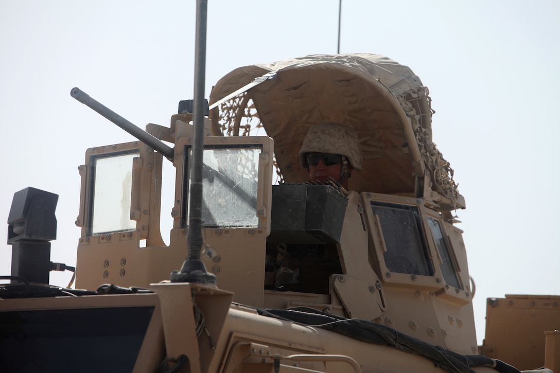 A gunner with the Personal Security Detachment, 1st Marine Logistics Group (Forward), provides security for a convoy escorting Brig. Gen. John J. Broadmeadow back to Camp Leatherneck, Afghanistan, Aug. 1. The PSD team ensures security for the commanding general when visiting any forward operating bases, combat outposts or patrol bases throughout Helmand Province that MLG Marines and sailors work out of.