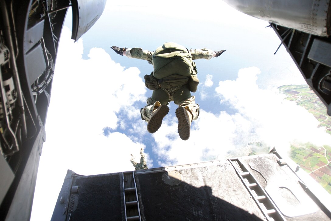 Service members jump out of a CH-46E Sea Knight helicopter during  parachute training over Ie Shima, Okinawa, Japan, July 26. Pilots with Marine Medium Helicopter Squadron 265 provided the jump platform via their CH-46Es to enable the training. The service members are with 1st Battalion, 1st Special Forces Group (Airborne), stationed at Torii Station. HMM-265 is with Marine Aircraft Group 36, 1st Marine Aircraft Wing, III Marine Expeditionary Force.  
