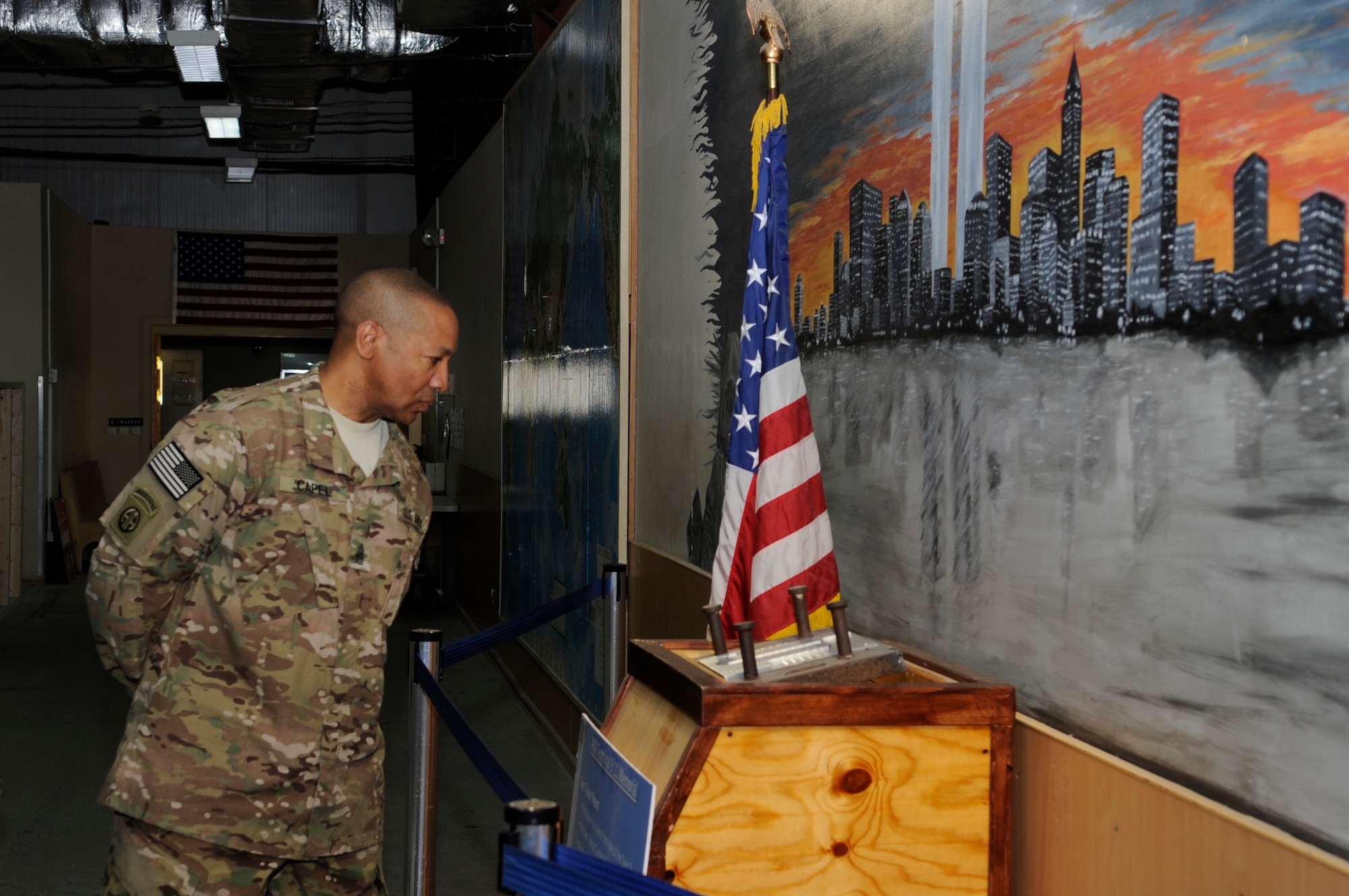 Army Command Sgt. Maj. Thomas Capel, International Security Assistance Force and United States Forces – Afghanistan senior enlisted advisor reads the inscription on the 9/11 memorial located in the customs processing area during a tour of the Transit Center at Manas, Kyrgyzstan, Aug. 1, 2012. Capel spent the day learning about the different mission functions of the Transit Center team and had the opportunity to thank all the service members assigned for their hard work, sacrifices and dedication in support of the ISAF mission. (U.S. Air Force photo/Master Sgt. Jason Vaught)