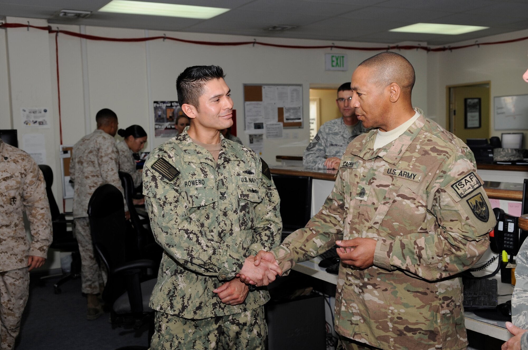 Army Command Sgt. Maj. Thomas Capel, International Security Assistance Force and United States Forces – Afghanistan senior enlisted advisor presents a superior performer coin to Petty Officer 1st Class Angel Romero during a tour of the Transit Center at Manas, Kyrgyzstan, Aug. 1, 2012. Romero who is deployed from Naval Air Station Coronado, Calif. serves as the U.S. Naval Forces Central Command lead liaison officer and is directly responsible for ensuring all Sailors heading to and from Afghanistan are equipped and prepared for their deployment. (U.S. Air Force photo/Master Sgt. Jason Vaught)

