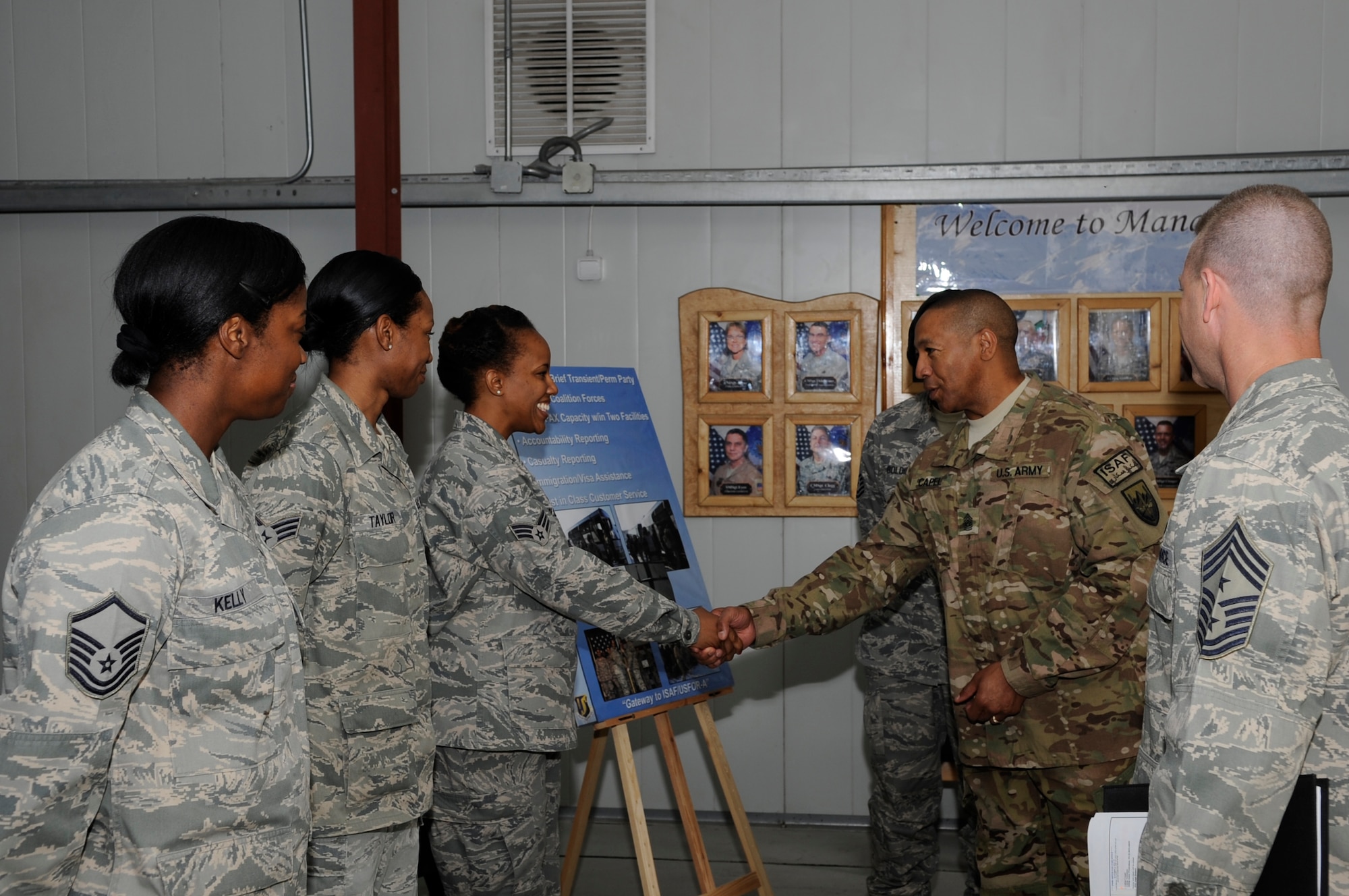 Army Command Sgt. Maj. Thomas Capel, International Security Assistance Force and United States Forces – Afghanistan senior enlisted advisor, presents a superior performer coin to Senior Airman Toneisha Wilson during a tour of the Transit Center at Manas, Kyrgyzstan, Aug. 1, 2012. Wilson briefed Capel on the Personnel Support for Contingency Operations team’s support function to the approximately 25,000 service members who process through the Transit Center each month. Capel took the time to personally thank each Soldier, Sailor, Airman, and Marine during his visit to the Transit Center. Wilson who works as military personnel flight specialist for PERSCO is deployed from Fairchild Air Force Base, Wash. and is a native of Columbus, Ga. (U.S. Air Force photo/Master Sgt. Jason Vaught)