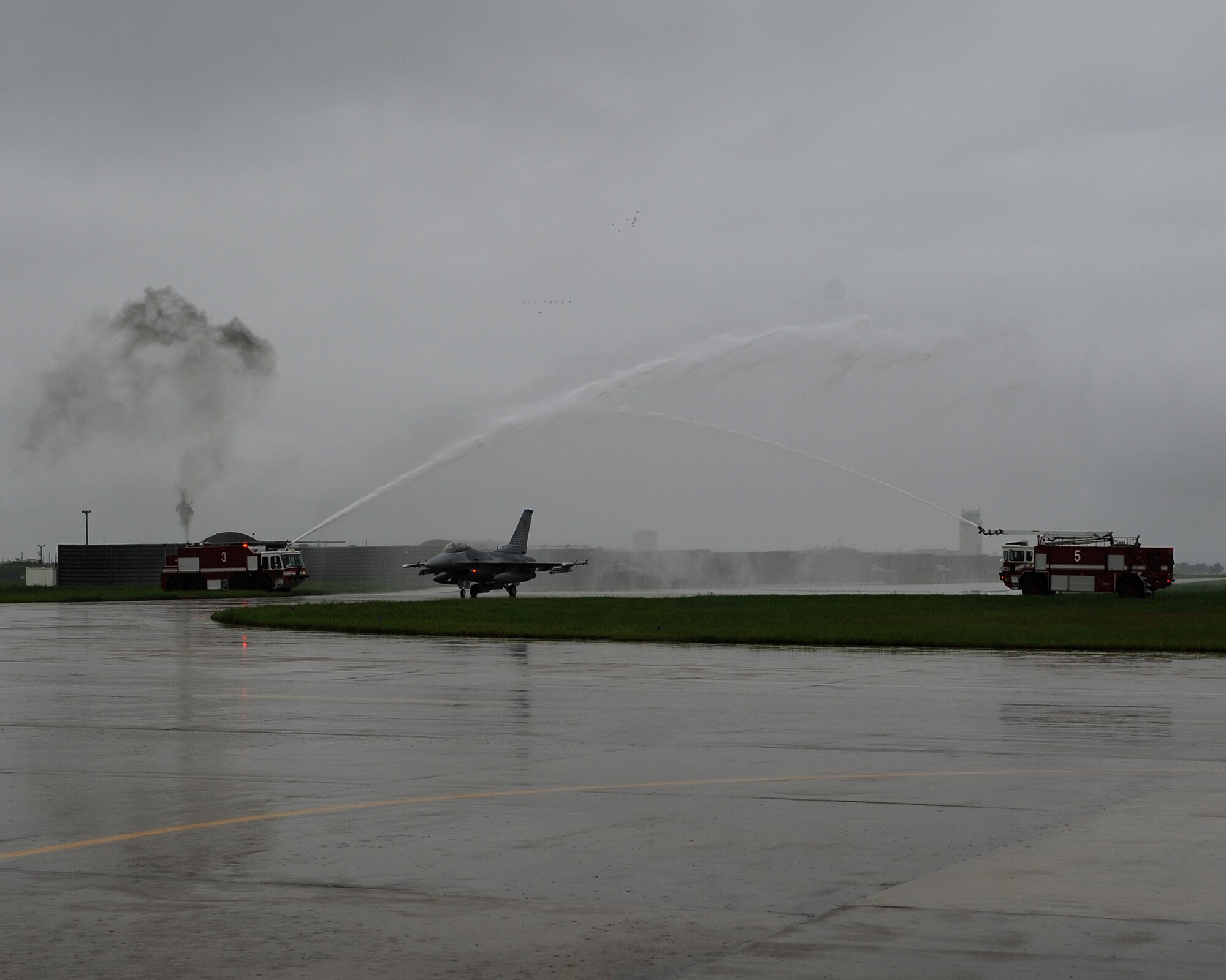 Gen. Gary North, Pacific Air Forces commander, taxis an F-16 Fighting Falcon between two fire trucks following his final flight at Kunsan Air Base, Republic of Korea, July 17, 2012. This flight was the last of four flights that North participated in during his final visit to Kunsan before his upcoming retirement after 36 years of service. (U.S. Air Force photo/Staff Sgt. Jonathan Fowler)