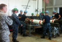 Chief Master Sgt. John Van Duser, 69th Aircraft Expeditionary Maintenance Unit superintendent, observes as Navy ordnance sailors build MK-62 mines in support of the Rim of the Pacific exercise. During the visit, Airmen from Team Anderson watched and learned from Naval ordnance techniques, equipment and teamwork. (U.S. Air Force photo by Master Sgt. Stephen Taylor/released)