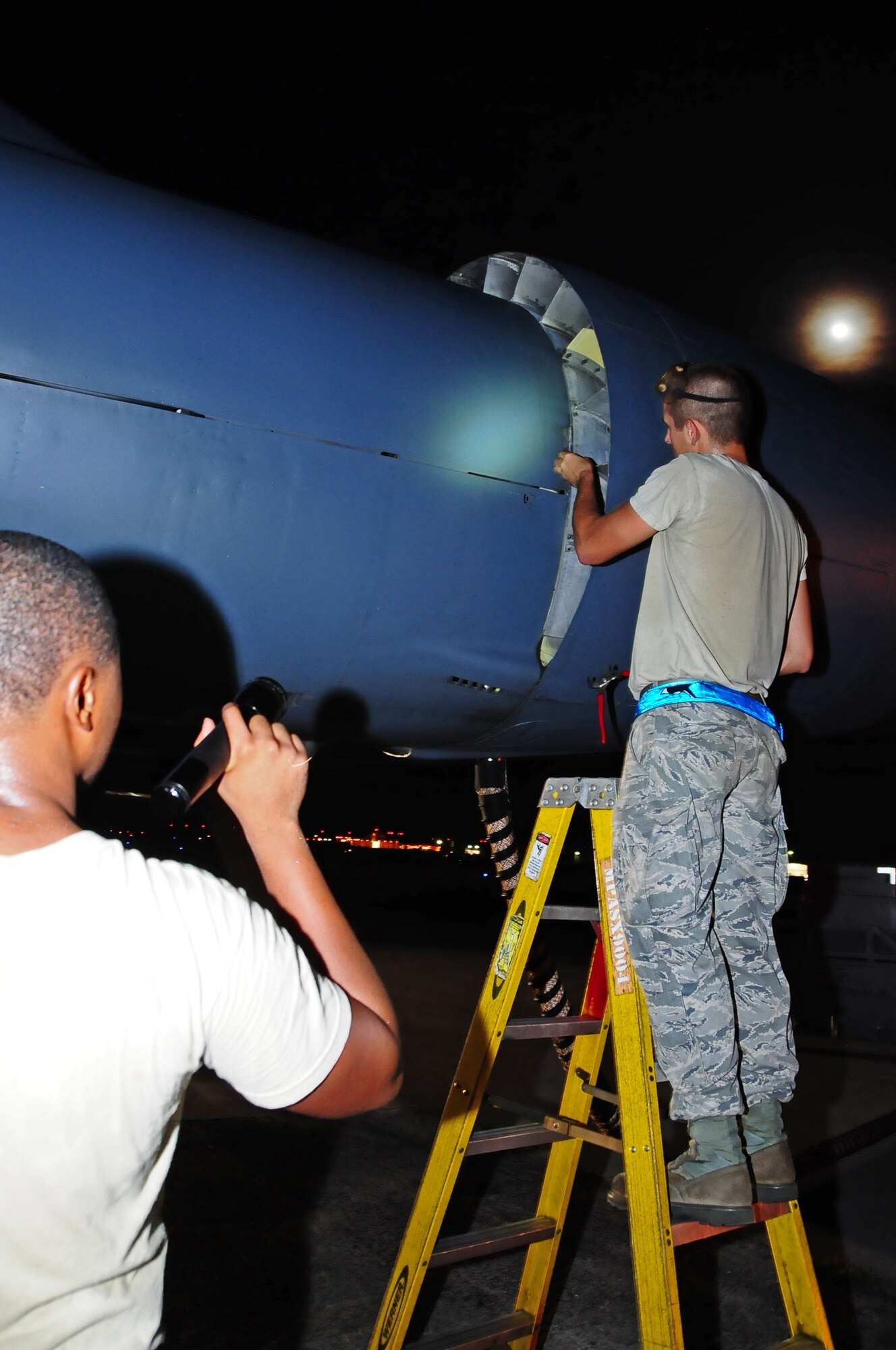 ANDERSEN AIR FORCE BASE, Guam -- Staff Sgt. Oliver Johnson, 36th Expeditionary Aircraft Maintenance Squadron crew chief, holds the flashlight while Airman 1st Class Bruce Brimm, 36th EAMXS crew chief, inspects the exterior of a B-52 Stratofortress here July 31. The 36th EAMXS Airmen make sure the B-52 is ready for the flight in support of the Rim of the Pacific Exercise. (U.S. Air Force photo by Airman 1st Class Marianique Santos/Released)