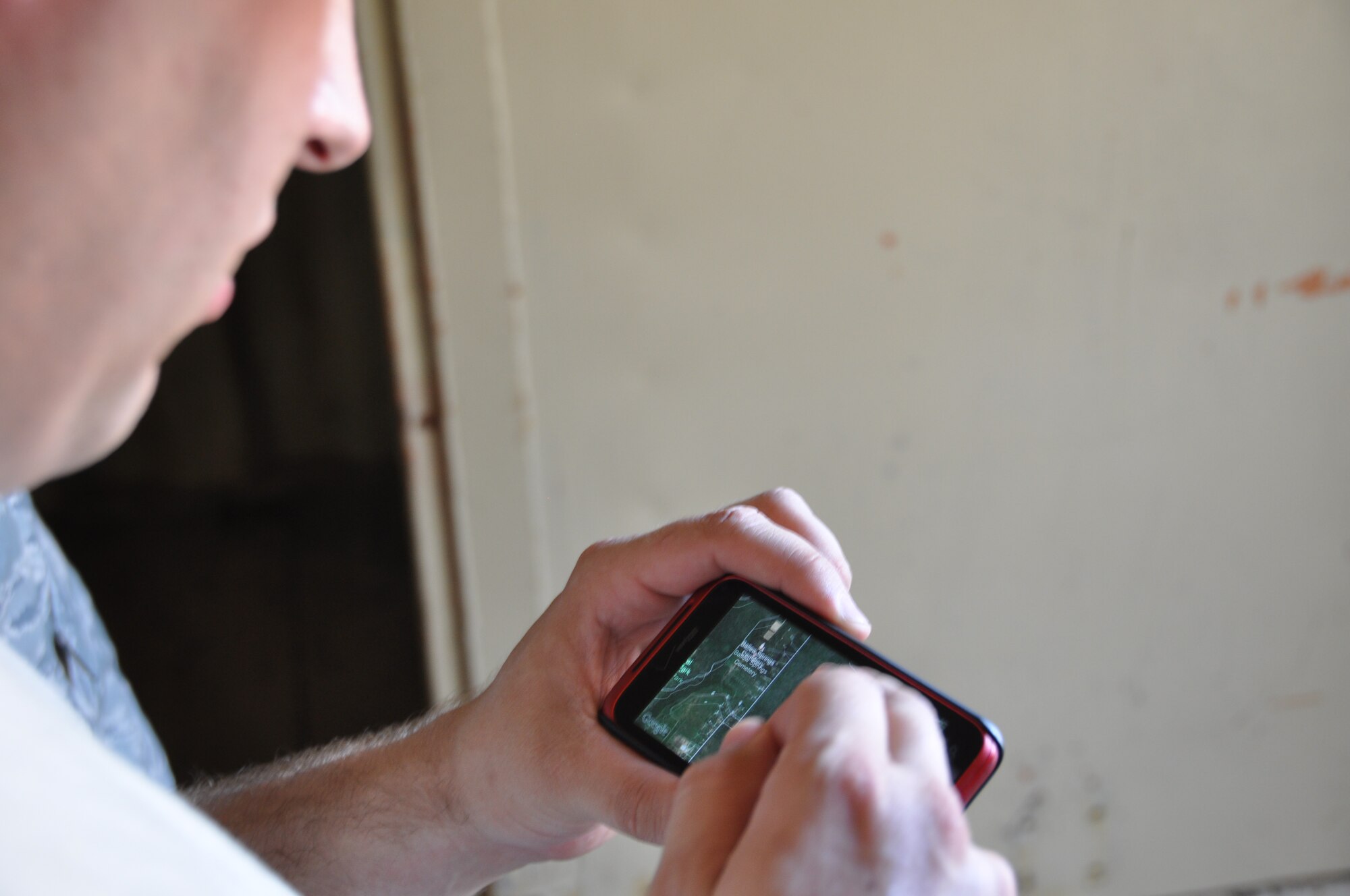 Staff. Sgt. Matthew Gordineer, 301st Civil Engineer Squadron Emergency Manager, uses a Geo Cam application on his cellphone to log the coordinates of 10 hidden orange cones during the land navigation course at Fort Wolters Army National Guard Facility, Monday, July 23. (U.S. Air Force photo/SrA Jeremy Roman) 