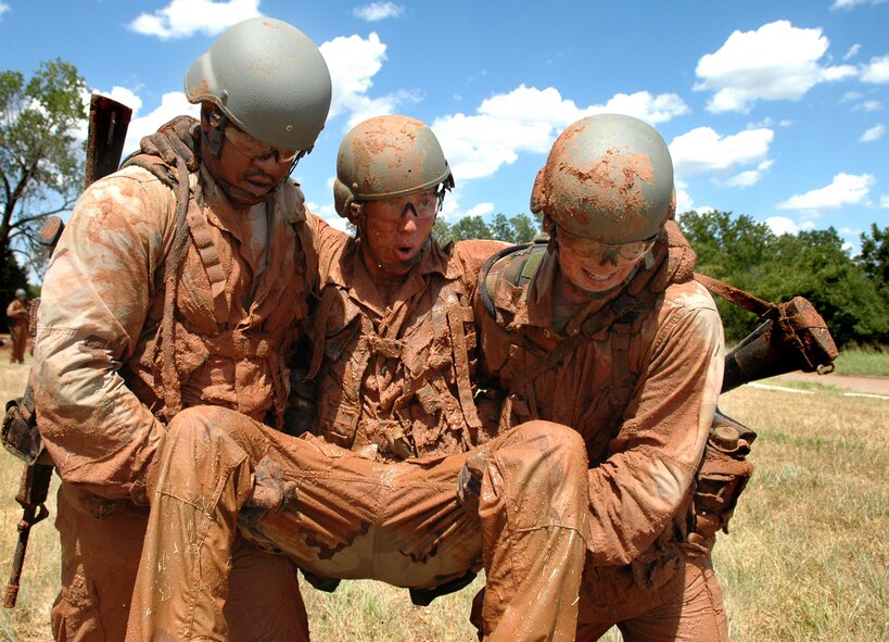 Staff Sgt. Toure Lyle, left,  Tech. Sgt. Daniel Means, both with 33rd Combat Communications Squadron, carry an Air Force Academy cadet, from one obstacle to another. Class members had to demonstrate three different buddy carries during the course. (Air Force photo by Micah Garbarino)