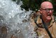 Staff Sgt. Jack McDaniel, 35th Combat Communications Squadron, cools off in a cold shower from a fire hose after tackling the Individual Movement Techniques course at the 3rd Combat Communications Groups Combat Readiness School at Tinker’s Glenwood Training Area July 25. Temperatures hovered just above 100 degrees. (Air Force photo by Micah Garbarino)
