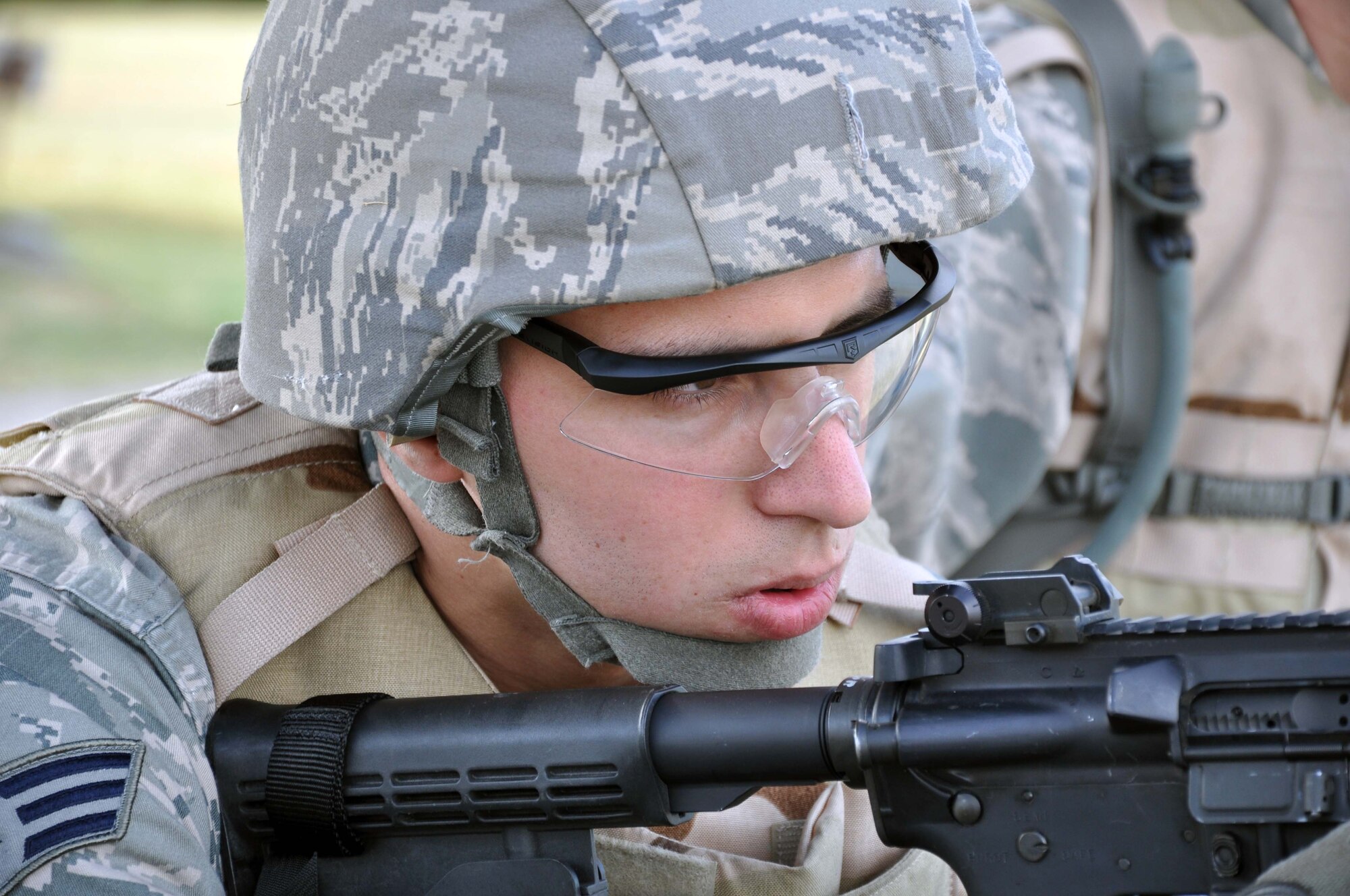 Senior Airman Michael Duvall, a Reservist assigned to the 931st Security Forces Squadron, McConnell Air Force Base, Kan., sites down the barrel of an M4 carbine rifle with an M203 grenade launcher attached.  Duvall was taking his turn firing the M203 at the base Combat Arms Training and Maintenance facility as part of a four-day field training excercise being conducted by the squadron in preparation for future deployments.  The M203 is a single-shot weapon that fires a 40mm grenade with an effective range of approximately 350 yards.  (U.S. Air Force photo by 1st Lt. Zach Anderson)