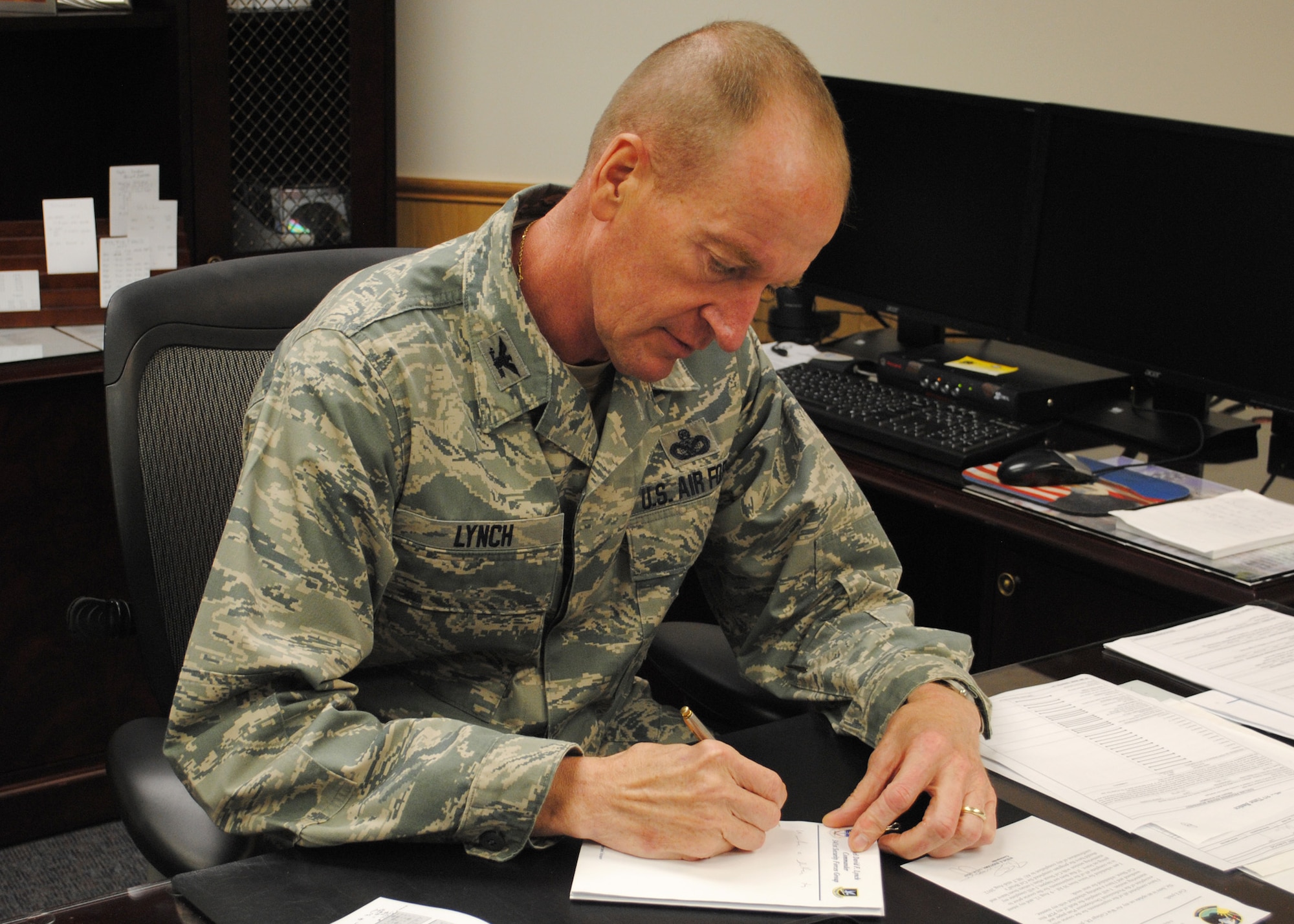 Col. David Lynch, 341st Security Forces Group commander, finishes up some paperwork in his office.  Lynch joined Team Malmstrom on June 10 and looks forward to leading the defenders of Wing One. (U.S. Air Force photo/Airman 1st Class Cortney Paxton)