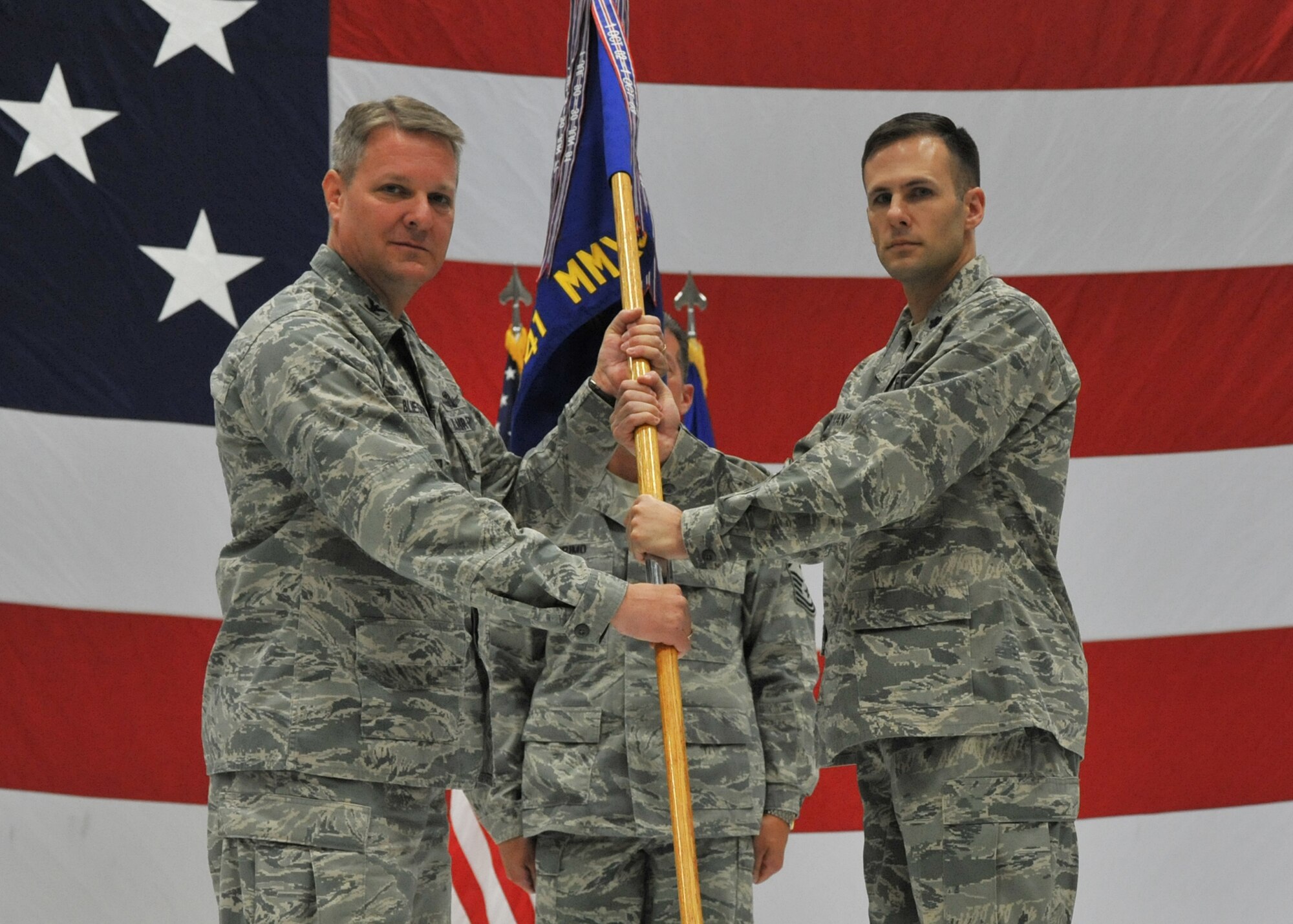 Lt. Col. Thomas Vance accepts command of the 341st Missile Maintenance Squadron from Col. David Bliesner, 341st Maintenance Group commander, on July 30 in the 3-Bay Hangar.  Chief Master Sgt. Michael Primo, 341st MMXS first sergeant, looks on.   (U.S. Air Force photo/ John Turner)