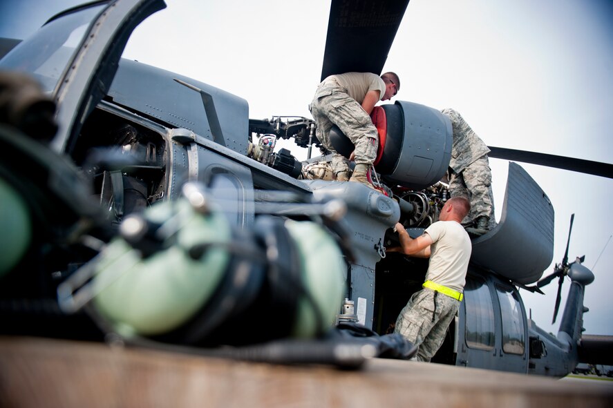Airmen of the 723d Aircraft Maintenance Squadron and 41st Helicopter Maintenance Unit install an HH-60G Pave Hawk v-band clamp July 31, 2012, at Moody Air Force Base, Ga. The v-band clamp holds the engine to other parts of the aircraft. (U.S. Air Force photo by Staff Sgt. Jamal D. Sutter/Released) 
