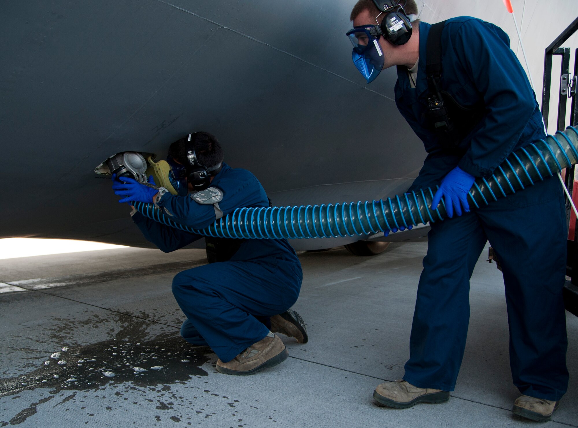 Airman 1st Class Micheal Echavarria and Senior Airman Brandon Ziegler, 60th Aerial Port Squadron fleet services, hook up a hose to a C-5 Galaxy Monday, to pump the waste out of the aircraft. (U.S. Air Force photo/Airman 1st Class Nicole Leidholm)