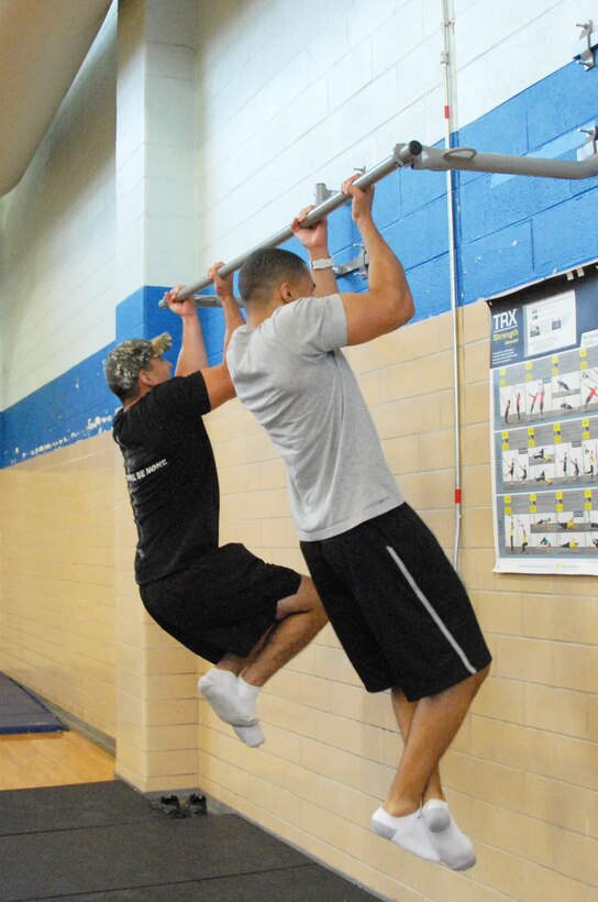 Sgt Craig Floyd (left), 138th Military Intelligence Company, and Senior Airman Mason Moore, 16th Airborne Command and Control Squadron do timed chin ups during the Phoenix Warrior Challenge hosted by 16th Airborne Command and Control Squadron, July 25. (U.S. Air Force photo by Misuzu Allen/Released)