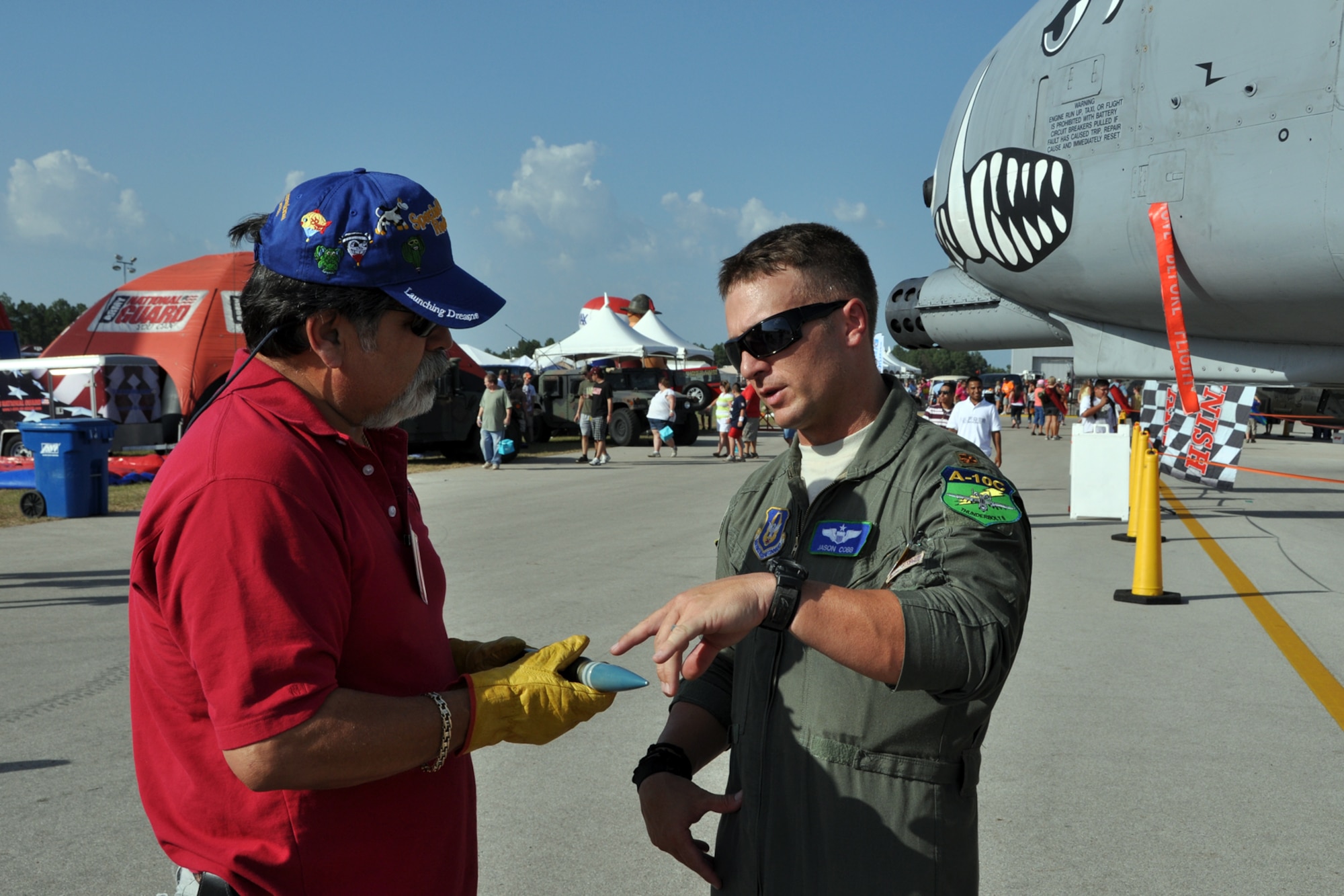 Maj. Jason Cobb, a pilot assigned to the 47th Fighter Squadron, Barksdale Air Force Base, La., explains the different types of 30 mm rounds used in the A-10 Thunderbolt II to Rudy Garza during the Great Texas Balloon Race 2012, at the East Texas Regional Airport in Longview, Texas, July 28, 2012. For the first time in the 35-year history of the event, the U.S. National Championships were held in conjunction with the annual event. (U.S. Air Force photo by Master Sgt. Jeff Walston)