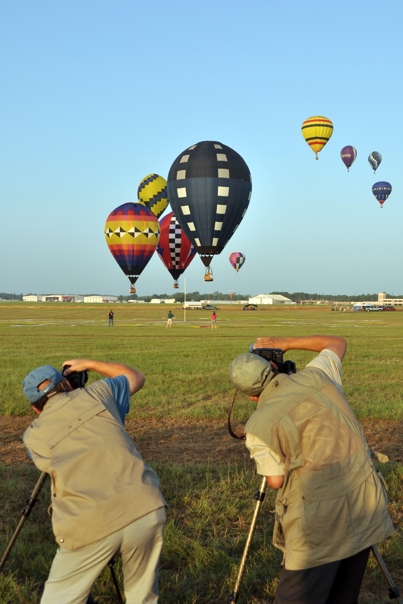 John Park (left) and Paul Ho capture a colorful spectacle during the Ring Toss Competition of the Great Texas Balloon Race 2012, at the East Texas Regional Airport in Longview, Texas, July 28, 2012. For the first time in the 35 year history of the event, the U.S. National Championships were held in conjunction with the annual event. (U.S. Air Force photo by Master Sgt. Jeff Walston)    