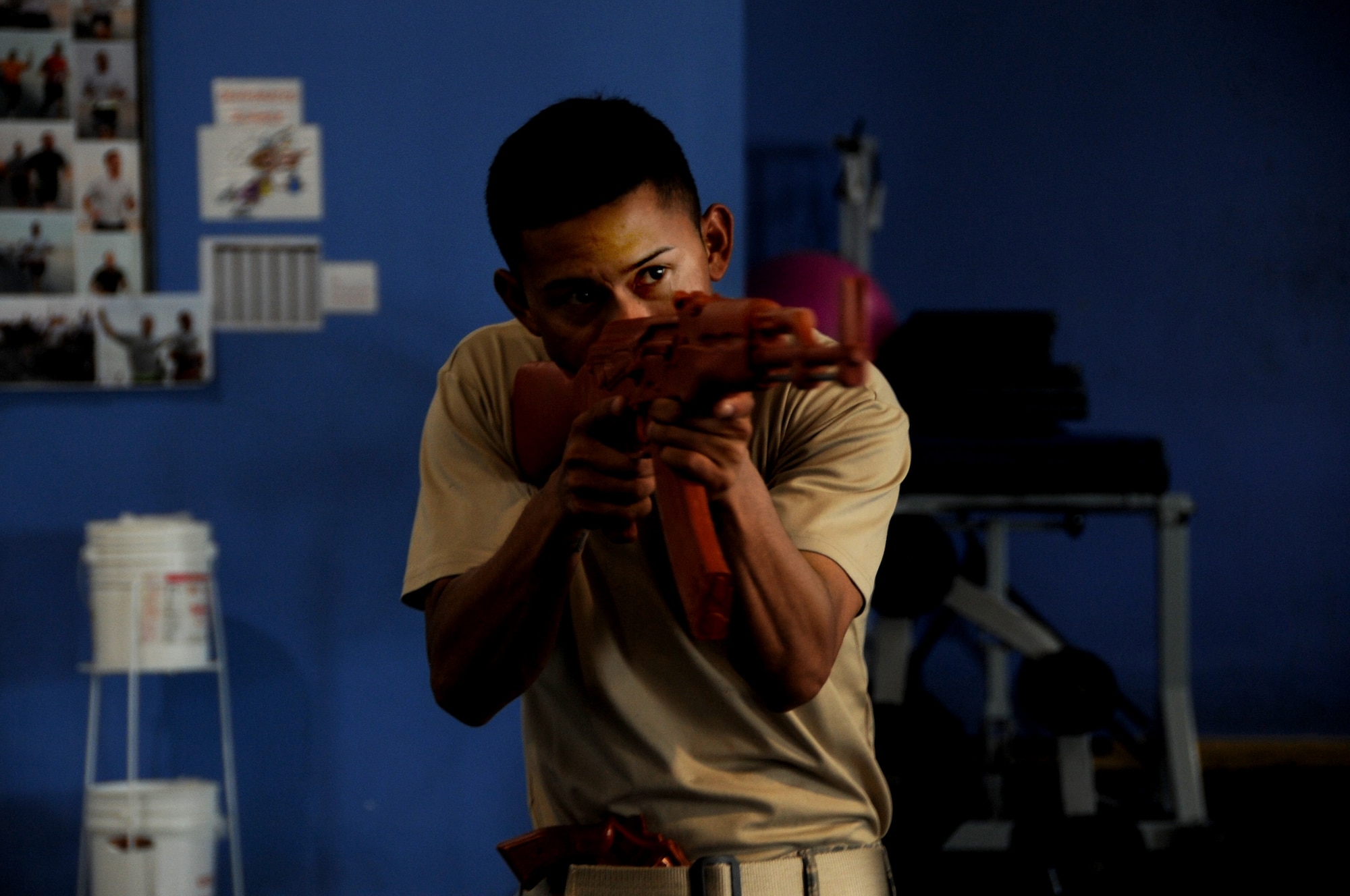 U.S. Air Force Staff Sgt. Angelo DeMesa, 379th Expeditionary Security Forces Squadron instructor and simulated active shooter, simulates a shooting spree during an exercise inside the BPC fitness center in Southwest Asia, July 30, 2012. The active-shooter exercise tested the defense and response capabilities of U.S. service members on the installation. DeMesa is deployed from Joint Base Lewis-McChord, Wash., and is a native of Angeles City, Philippines. (U.S. Air Force photo/Staff Sgt. Sheila deVera)