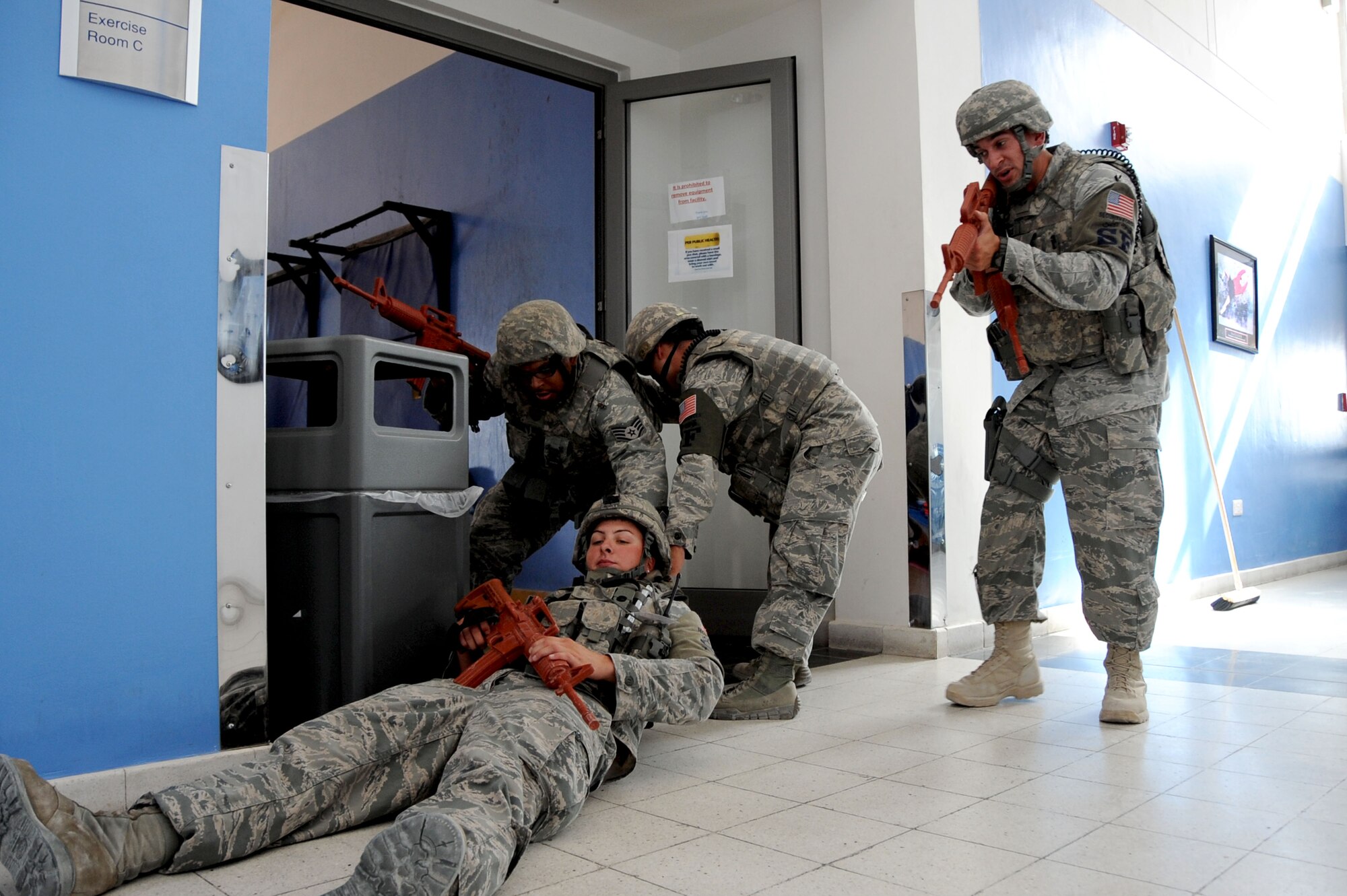 Members from the 379th Expeditionary Security Forces Squadron pull a fellow defender to safety during an active-shooter exercise inside the BPC fitness center in Southwest Asia, July 30, 2012. The active shooter exercise tested the defense and response capabilities of U.S. service members on the installation. (U.S. Air Force photo/Staff Sgt. Sheila deVera)