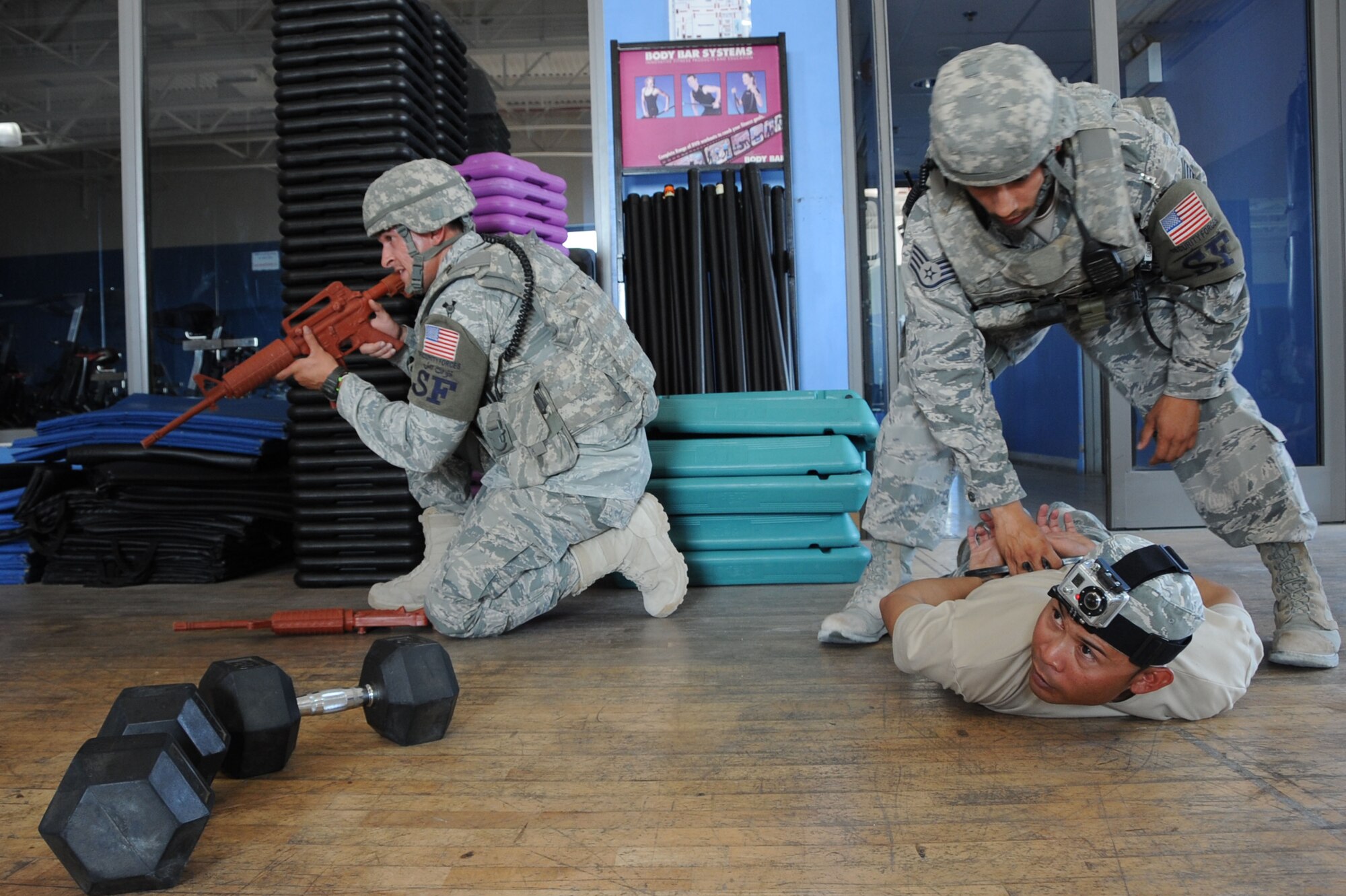 Members from the 379th Expeditionary Security Forces Squadron apprehend Staff Sgt. Angelo DeMesa, 379th ESFS instructor and simulated active shooter, during an exercise inside the BPC fitness center in Southwest Asia, July 30, 2012. The active-shooter exercise tested the defense and response capabilities of U.S. service members. DeMesa is deployed from Joint Base Lewis-McChord, Wash., and is a native of Angeles City, Philippines. (U.S. Air Force photo/Staff Sgt. Sheila deVera)