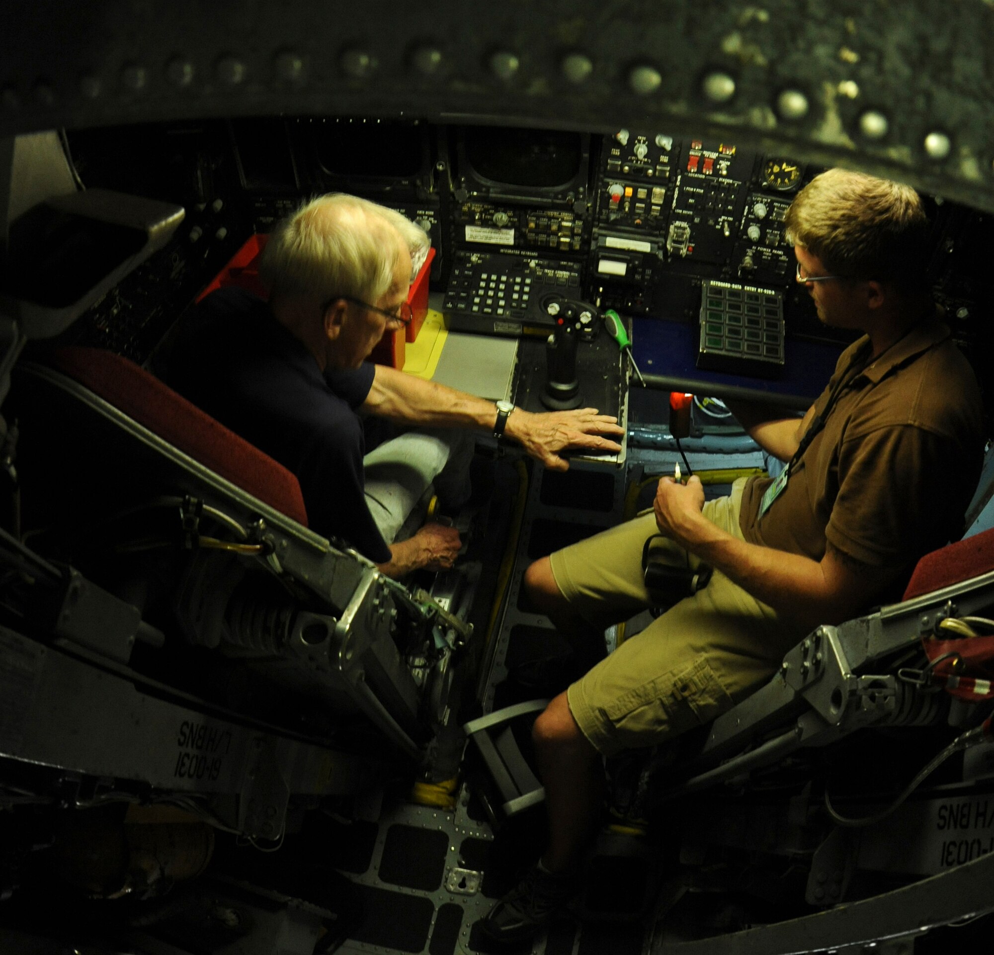 Bill Overman,left, VSE Corporation aircraft sheet metal technician, and Robert Prock, VSE Corp electronic technician III, installs wiring for a Sniper pod targeting system in a B-52H Stratofortress on Barksdale Air Force Base, La., Aug. 1. The new system will provide aircrews with better imagery along with quicker repair times for maintenance Airmen. (U.S. Air Force photo/Airman 1st Class Micaiah Anthony)(RELEASED)