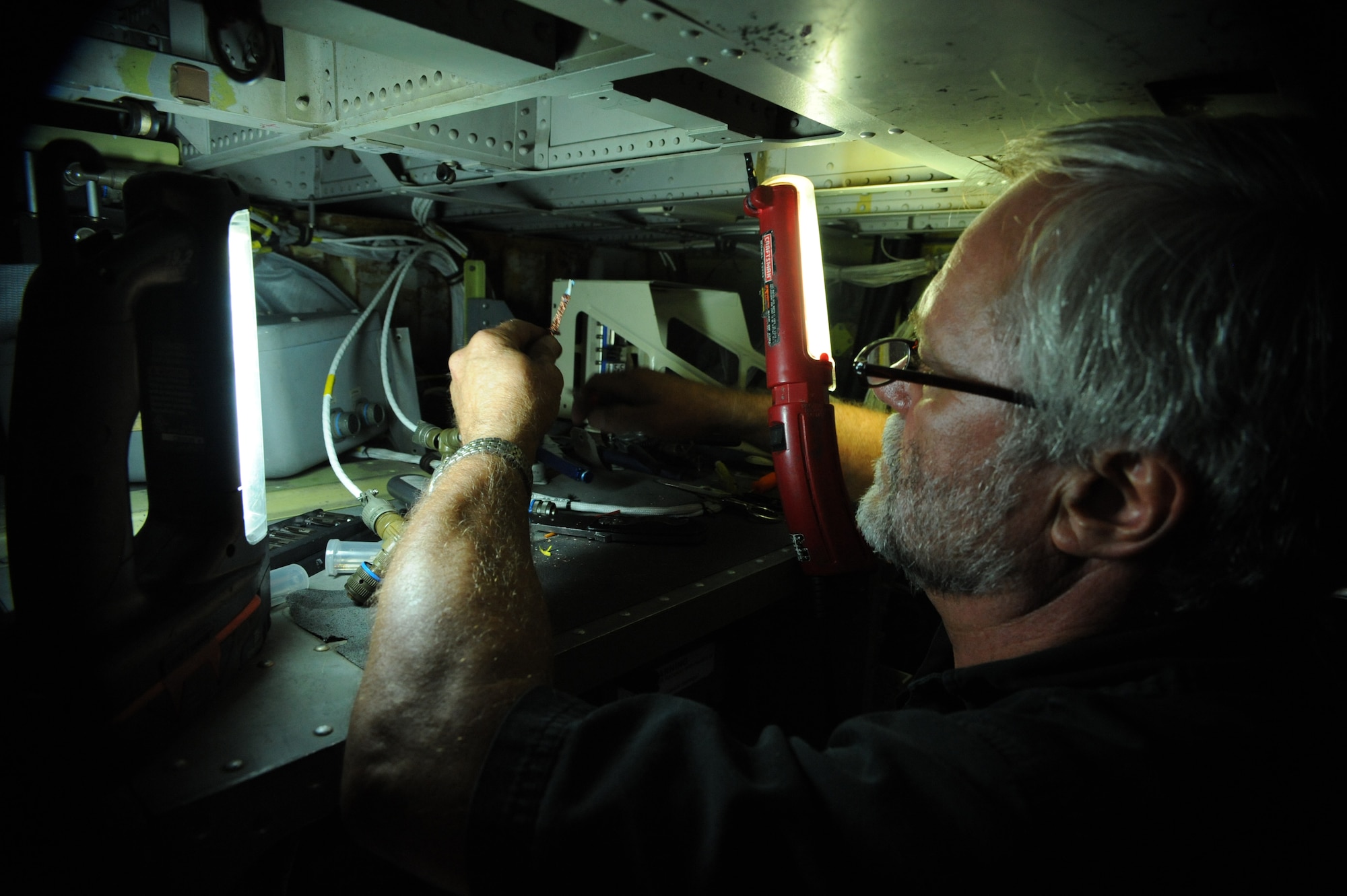 Larry Cook, VSE Corporation aircraft mechanic III, installs wiring for a Sniper pod targeting system in a B-52H Stratofortress on Barksdale Air Force Base, La., Aug. 1. Contractors from VSE Corp were called in to install wiring for a targeting system called the Sniper pod. The pods help aircrews verify targets, communicate with controllers and direct laser guided munitions. (U.S. Air Force photo/Airman 1st Class Micaiah Anthony)(RELEASED)