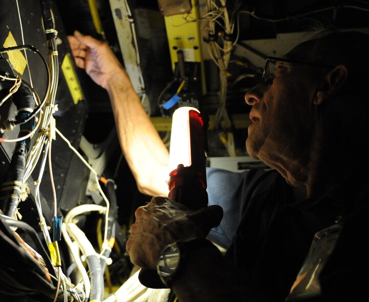 Bill Overman, VSE Corporation aircraft sheet metal technician, pulls a wire through an opening on a B-52H Stratofortress on Barksdale Air Force Base, La., Aug. 1. Contractors from VSE Corp were called in to install wiring for a targeting system called the Sniper pod. The pods help aircrews verify targets, communicate with controllers and direct laser guided munitions. (U.S. Air Force photo/Airman 1st Class Micaiah Anthony)(RELEASED)