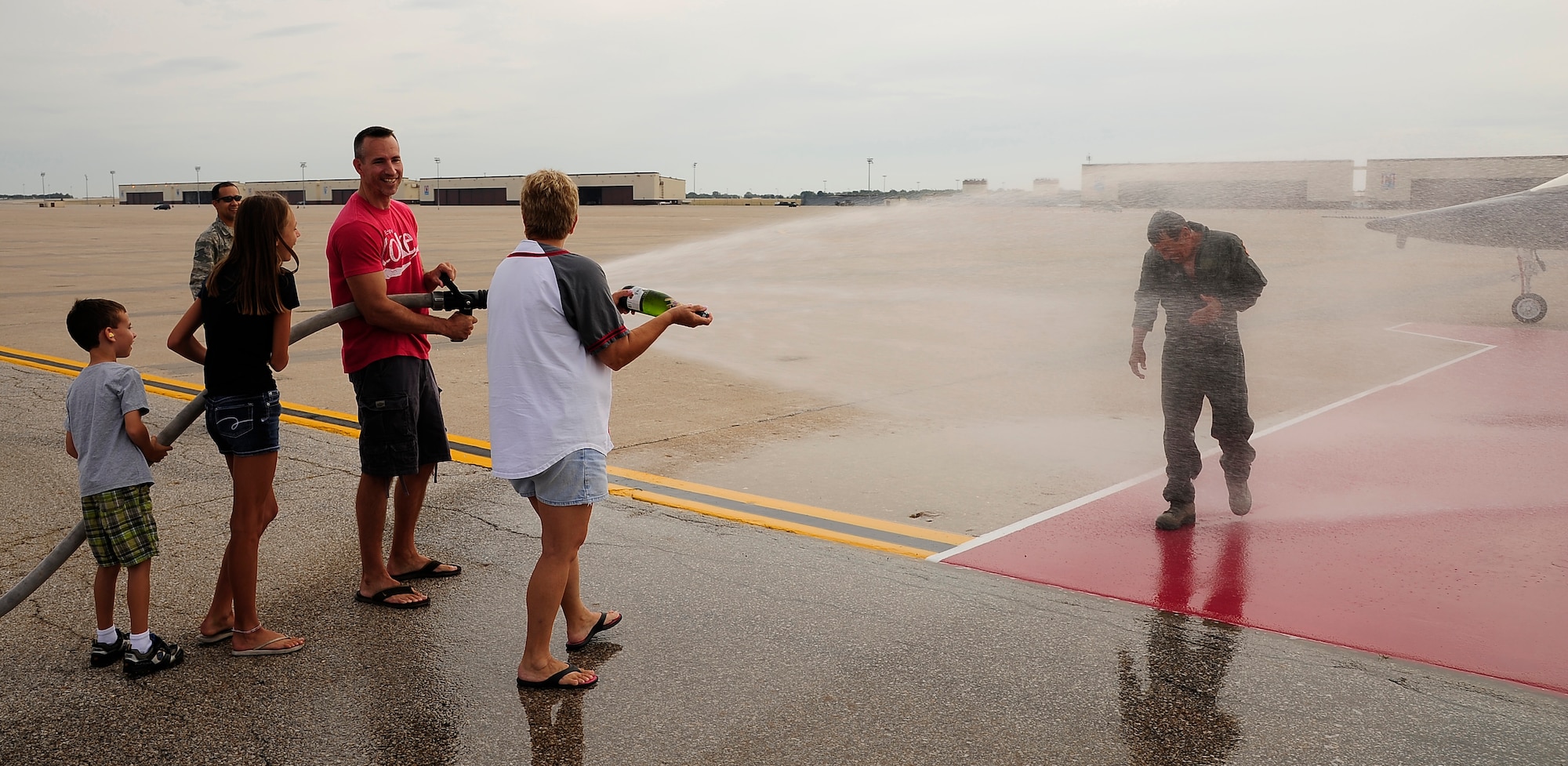 WHITEMAN AIR FORCE BASE, Mo. -- Al Cox is sprayed by his family after a T-38 Talon incentive flight here, July 31. Cox retired Aug. 1, after 47 years of service as active duty Air Force Airman and a contractor. (U.S. Air Force photo/ Senior Airman Cody H. Ramirez)