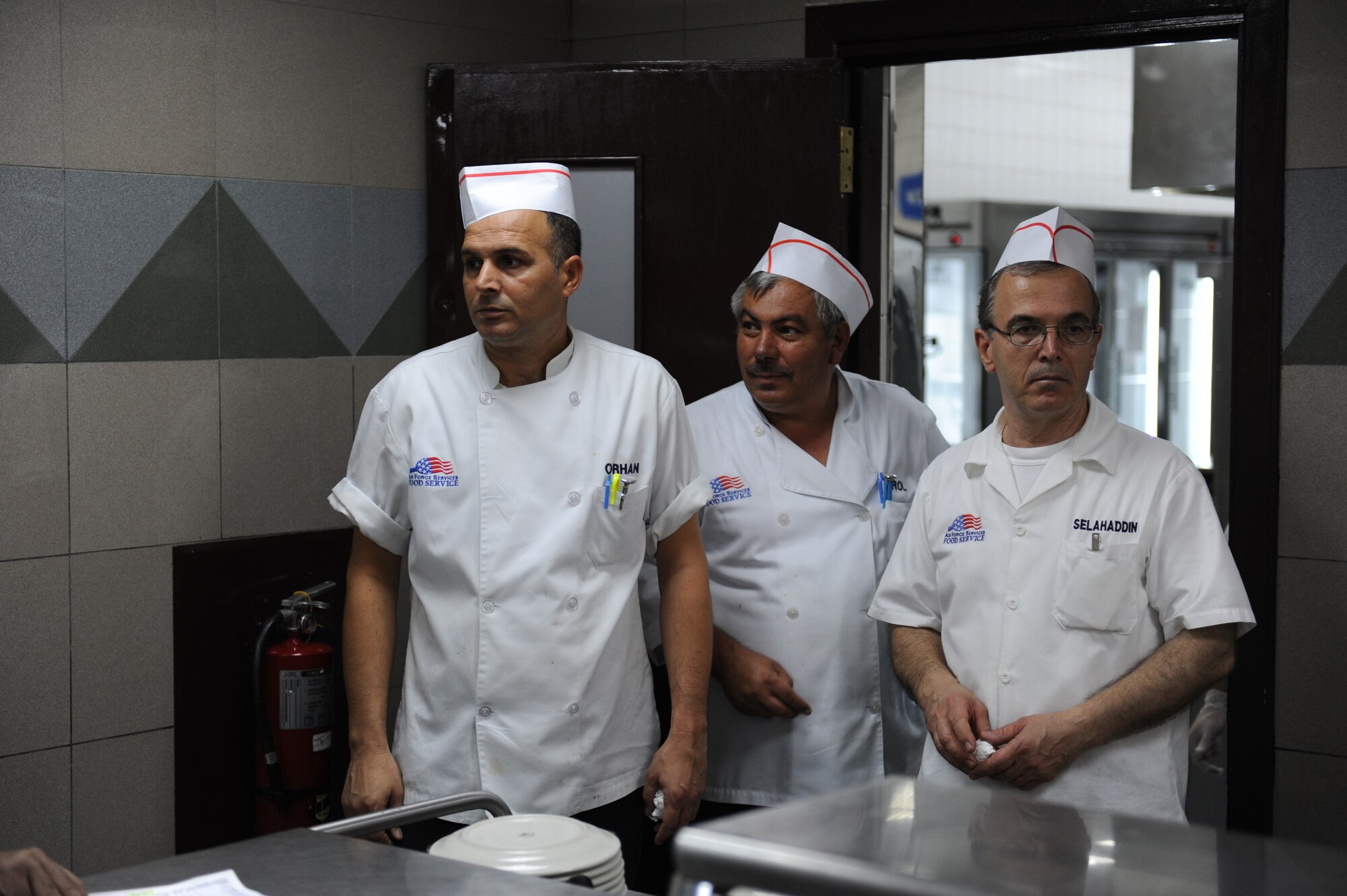 Orhan Kisial, 39th Force Support Squadron senior cook, Naci Erol, 39th FSS senior cook, and Selahaddin Aydin, 39th FSS food services helper, talk before the dining facility opens July 27, 2012, at the Sultan's Inn Dining Facility at Incirlik Air Base, Turkey. The Sultan's Inn offers breakfast, lunch, dinner and early breakfast on weekends. (U.S. Air Force photo by Senior Airman William A. O'Brien/Released) 