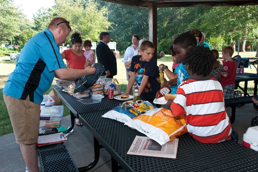 HANSCOM AIR FORCE BASE, Mass. – Master Sgt. Raymond Merring (left), from the Airman and Family Readiness Center, prepares food to be served at the Hearts Apart event held in Castle Park July 25. Hearts Apart is specifically designed for families of deployed and extended temporary duty servicemembers. The gatherings allow families to connect by participating in fun events while offering them a forum to discuss deployment-related concerns and issues. (U.S. Air Force photo by Mark Herlihy)