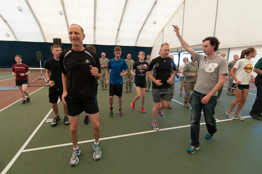 HANSCOM AIR FORCE BASE, Mass. - Matt Capstick (front, right), New Balance regional coordinator, uses a metronome application to explain the cadence that runners should follow during a Good Form running fundamentals clinic July 25 in the Tennis Bubble. Hosted by the Fitness Center, participants ran in place while the representative explained strategies to improve running form. (U.S. Air Force photo by Rick Berry)