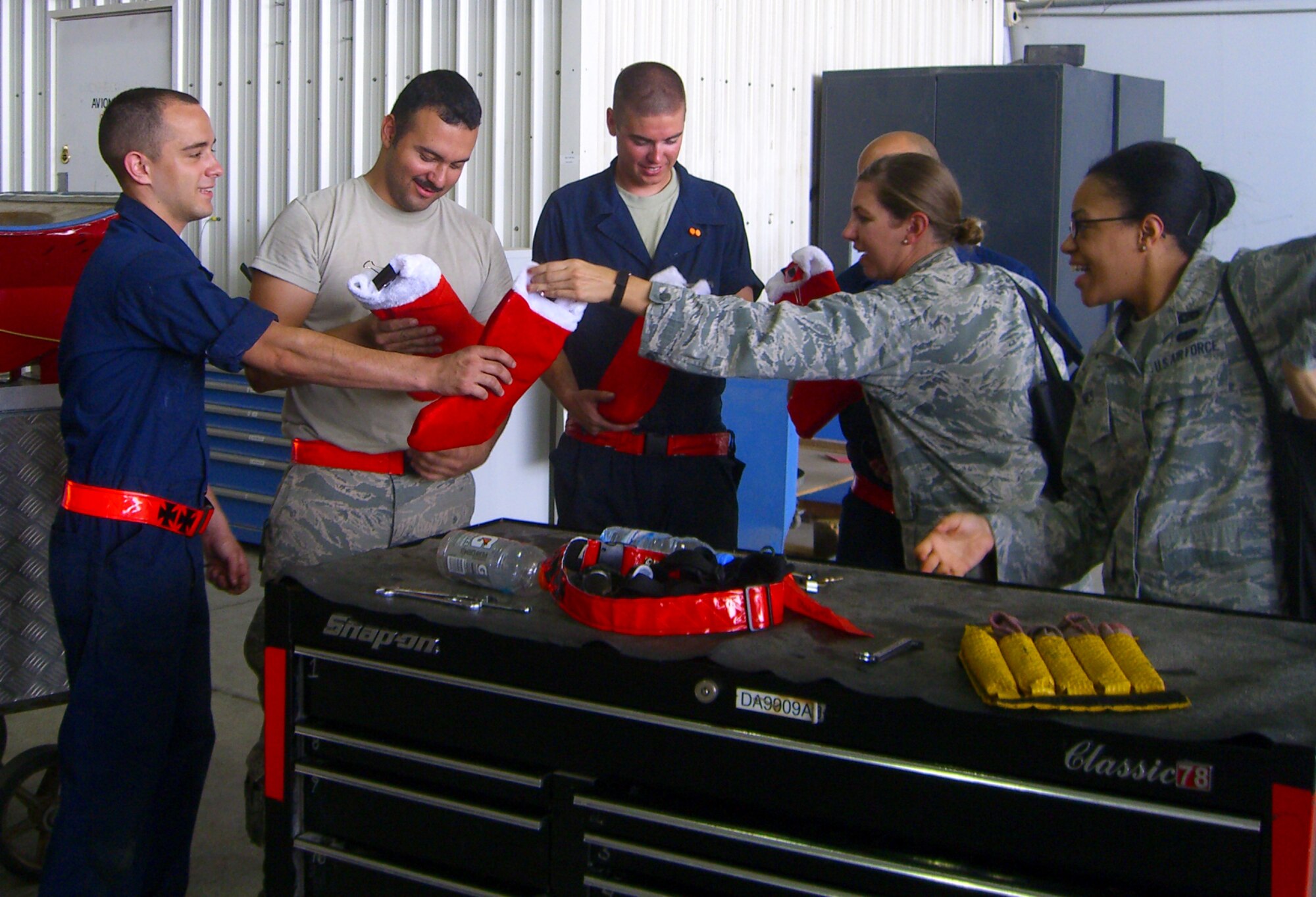 SOUTHWEST ASIA -- U.S. Air Force Capt. Sara Ortbals, 380th Air Expeditionary Wing Sexual Assault Prevention and Response Coordinator, and Tech. Sgt. Jasmine Barnes, 380th AEW Equal Opportunity officer, deliver stockings to aircraft maintainers here July 28, 2012. Wing support agencies passed stockings full of items from a stateside corporation to people here as "Christmas in July"-themed gifts. (U.S. Air Force photo)