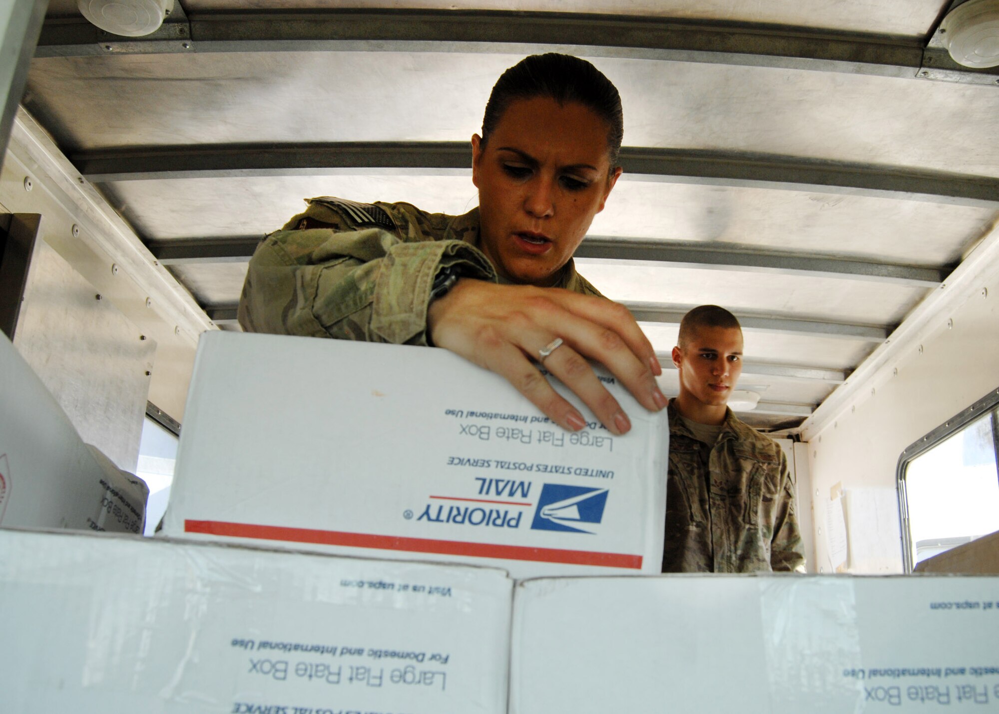 U.S. Air Force Senior Airman Shannon Koutsovalas, 451st Air Expeditionary Wing mail clerk, checks address labels on packages to ensure they are sorted into the correct unit bins while unloading the mail truck near Camp Losano here July 31. (U.S. Air Force photo/Master Sgt. Russell Martin/RELEASED)