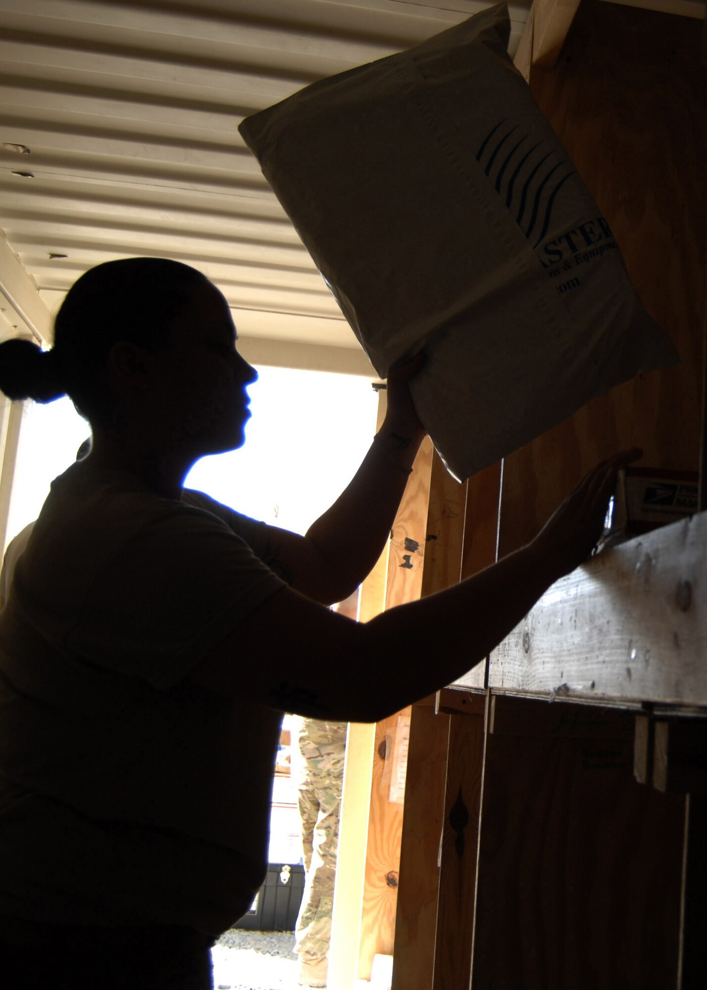 U.S. Air Force Staff Sgt. Daida Garcia-Ortiz, 451st Expeditionary Security Forces Squadron mail augmentee, separates unit packages into the appropriate bins in a conex outside Camp Losano here July 31.  (U.S. Air Force photo/Master Sgt. Russell Martin/RELEASED)