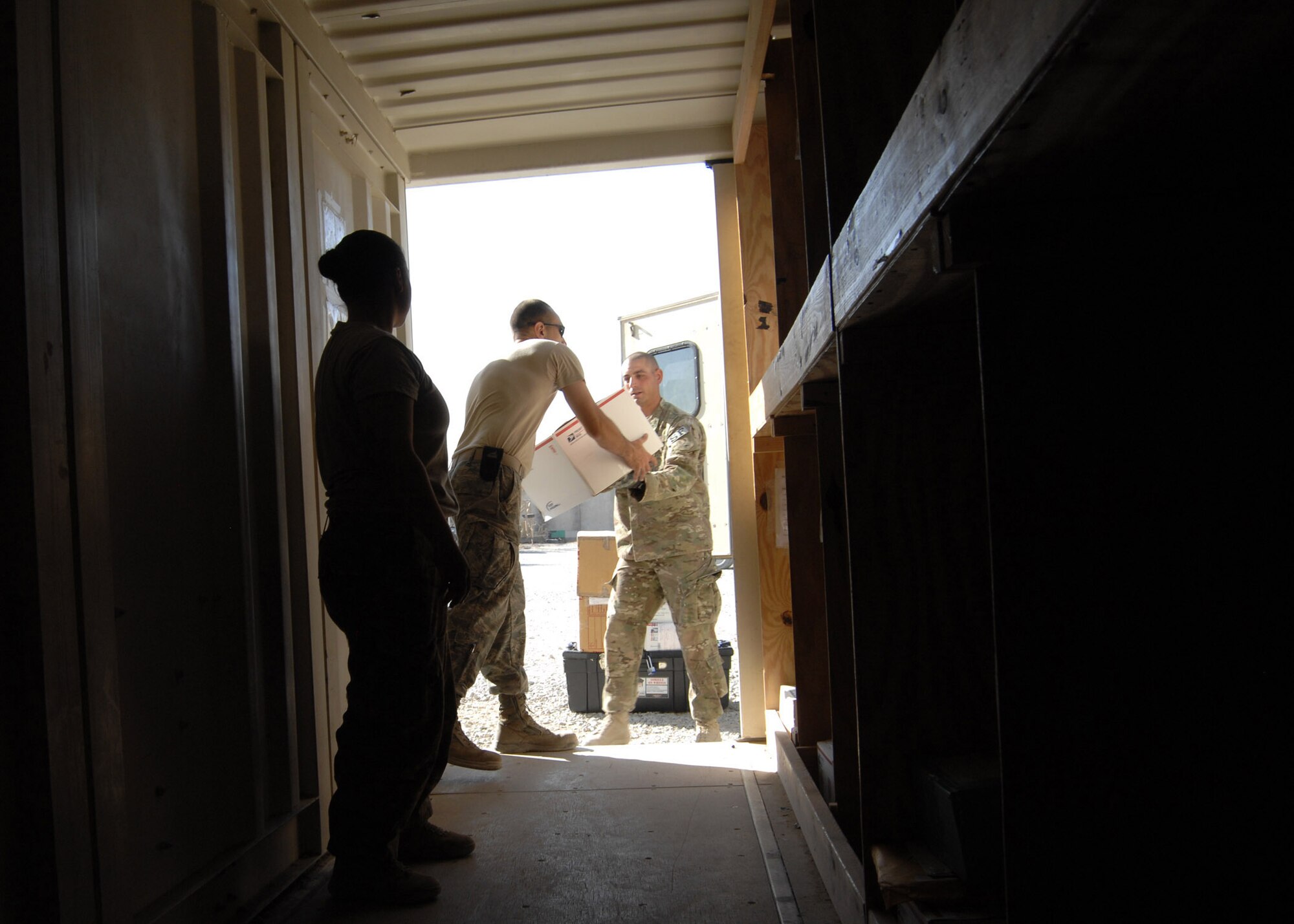 451st Air Expeditionary Wing Airmen unload mail at the conexes outside Camp Losano here July 31. The storage containers are separated by units in the wing allowing for ease of collection by unit mail representatives.   (U.S. Air Force photo/Master Sgt. Russell Martin/RELEASED)