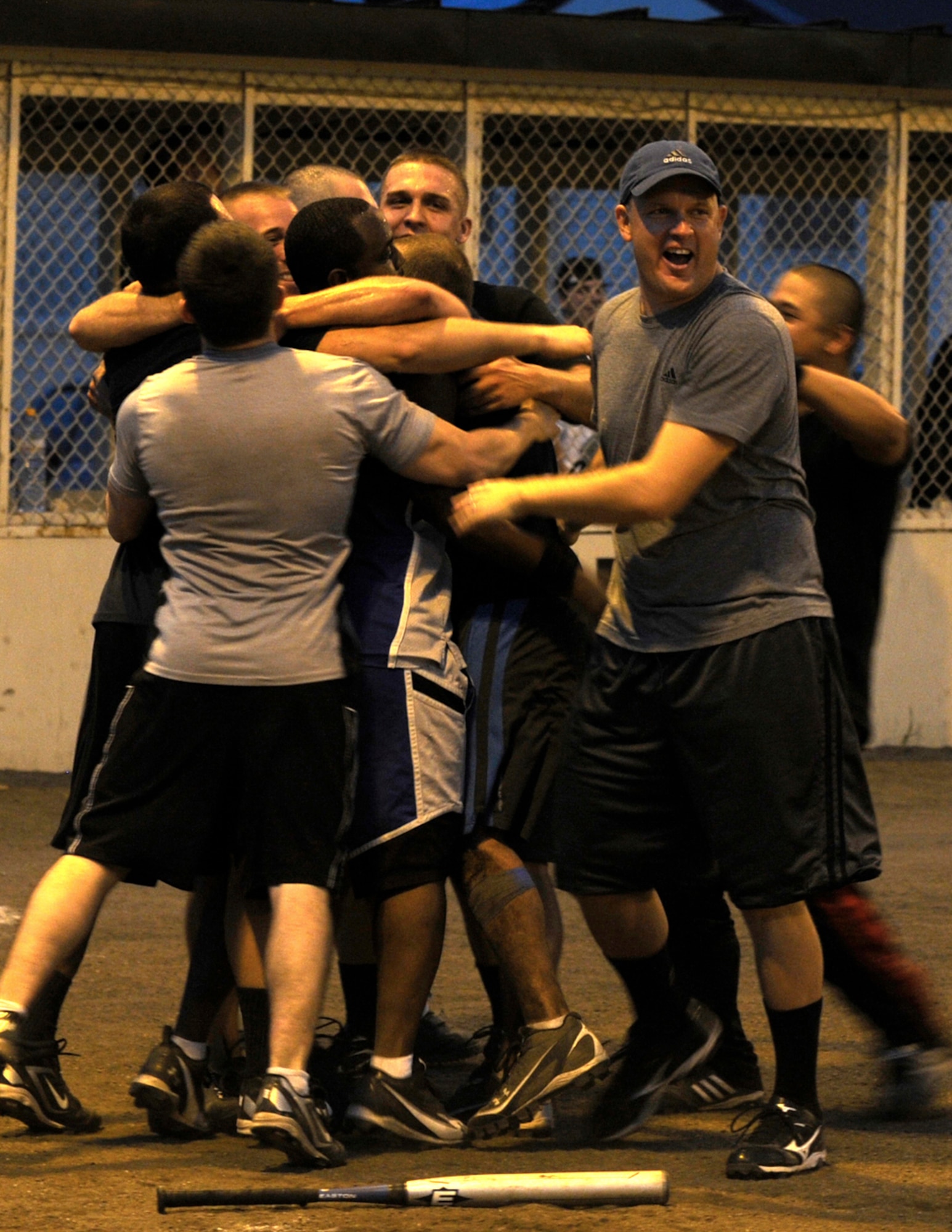 Members of the Commander Task Force 72 softball team celebrate together after hitting a walk-off base hit that scored the game winning run during the intramural softball championship game at Misawa Air Base, Japan, Aug. 1, 2012. CTF-72 beat the 35th Force Support Squadron softball team by a score of 14 to 13. (U.S. Air Force photo by Airman 1st Class Zachary Kee/Released)