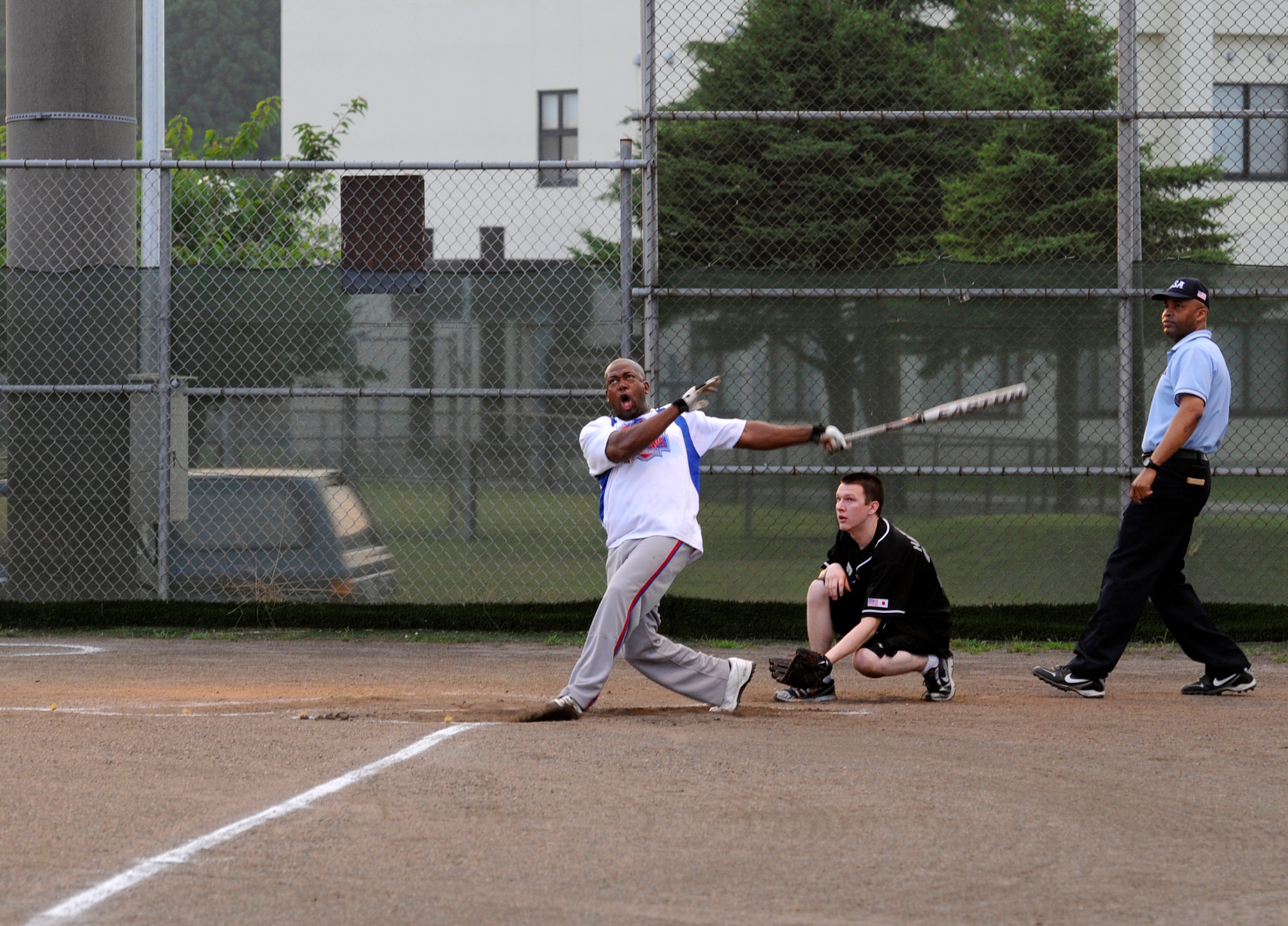 U.S. Navy Chief Petty Officer Terry Oliver, Commander Task Force 72 pitcher, watches the ball leave his bat and go over the fence for a homerun during the intramural softball championship game at Misawa Air Base, Japan, Aug. 1, 2012. In intramural softball, each team is only allowed to hit five homeruns a game. After five a homerun is recorded as an out. During the championship game both CTF-72 and the 35th Force Support Squadron hit their five homerun limit. CTF-72 beat the 35 FSS 14 to 13 in seven innings. (U.S. Air Force photo by Airman 1st Class Zachary Kee/Released)