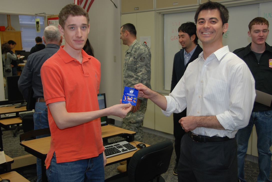John Feller (r), Japan District Engineer, presents a gift card to David Bordenave who earned the first place during the 2012 West Point Bridge Design Contest. (Official Japan Engineer District photo by T.W. Lyman)