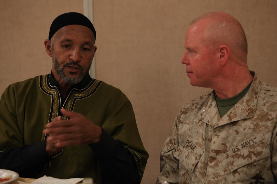 Shakir Fardan, a volunteer military spiritual leader, speaks with U.S. Navy Cmdr. Edward S. Pease during an Iftar meal celebration at the Blinder Memorial Chapel, Aug. 2.  Iftar allows fasting Muslims to break fast with an evening meal that takes place at sunset each night during the Islamic holy month of Ramadan.::r::::n::