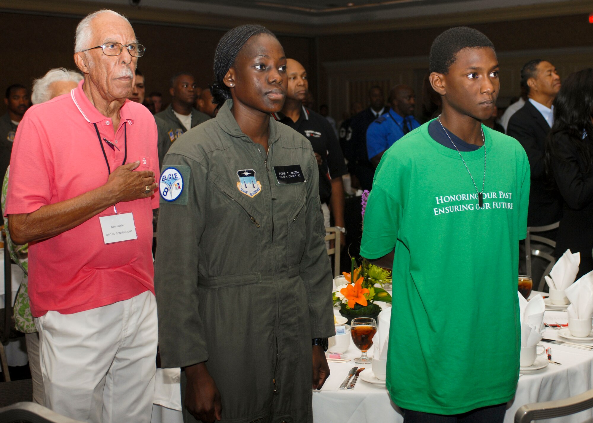 Retired Capt. Samuel Hunter Jr. and a group of youths render respect as the national anthem is sung during a youth lunch Aug. 2, 2012 in downtown Las Vegas, Nev. during the 41st Annual Tuskegee Airmen, Inc. National Convention. Youth at the lunch were reminded of the past, while given guidance for their futures. (U.S. Air Force photo by Senior Airman Jack Sanders)
