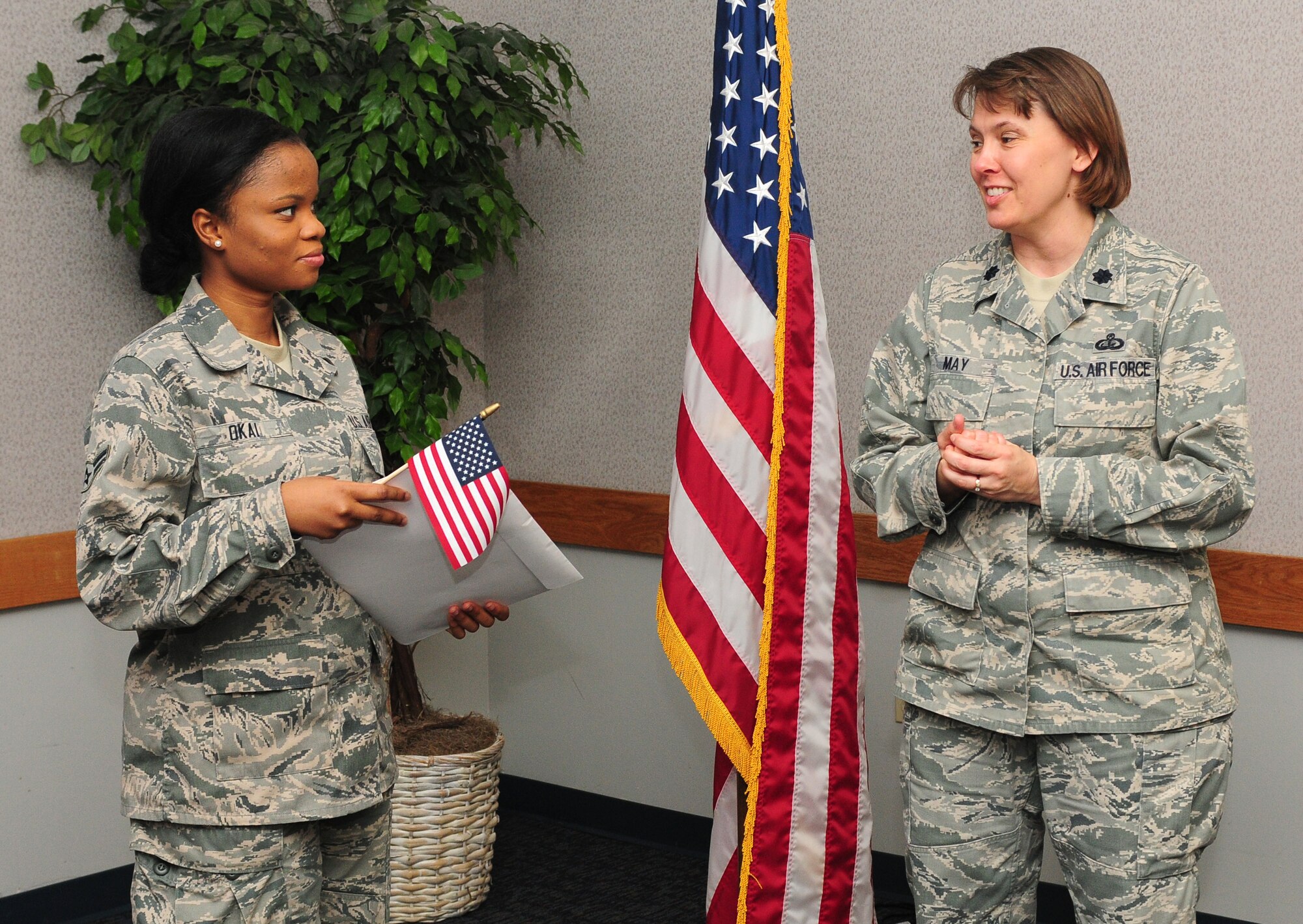 Airman 1st Class Princess Okai, 9th Force Support Squadron, food service apprentice is congratulated by Lt. Col. Connie May, 9th FSS Commander on becoming an American citizen at the Airman Family Readiness Center at Beale Air Force Base Calif., July 27, 2012. Okai said she joined the Air Force to travel and improve her education. (U.S. Air Force photo by Senior Airman Allen Pollard/Released)