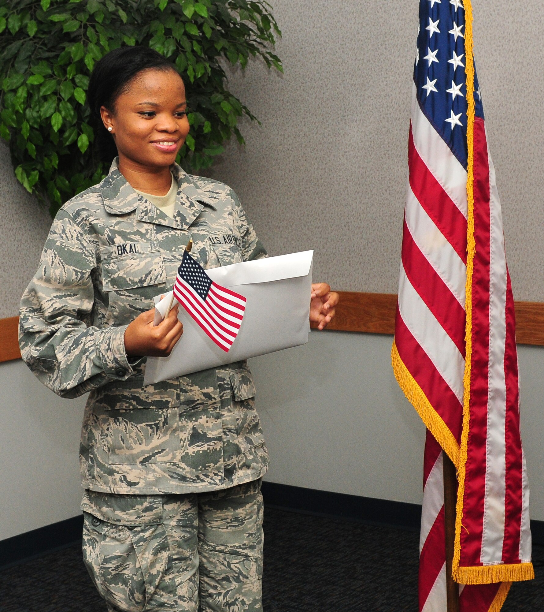 Airman 1st Class Princess Okai, 9th Force Support Squadron, food service apprentice holds an American flag and her citizenship paperwork at the Airman Family Readiness Center at Beale Air Force Base Calif., July 27, 2012. Okai was born in Ghana, West Africa, her and family moved to Long Island, N.Y. in 2007. (U.S. Air Force photo by Senior Airman Allen Pollard/Released)