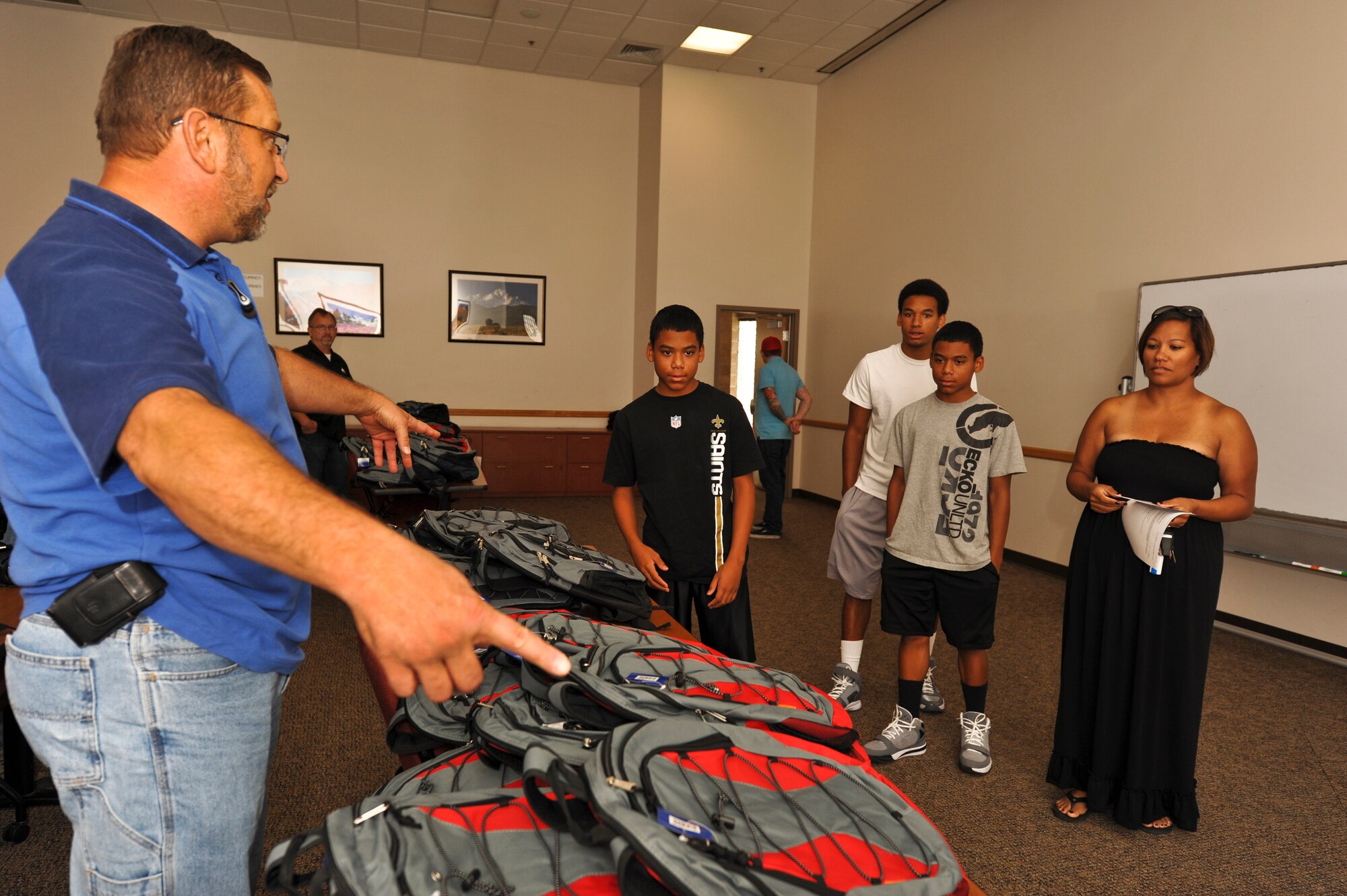 BUCKLEY AIR FORCE BASE, Colo. – Rory Eccher, Operation Homefront, shows the Smashum family which backpacks are for elementary and high school students Aug. 3, 2012.  Operation Homefront provided more than 150 school-supply-filled backpacks to students of service members. (Air Force photo by Senior Airman Christopher Gross)  