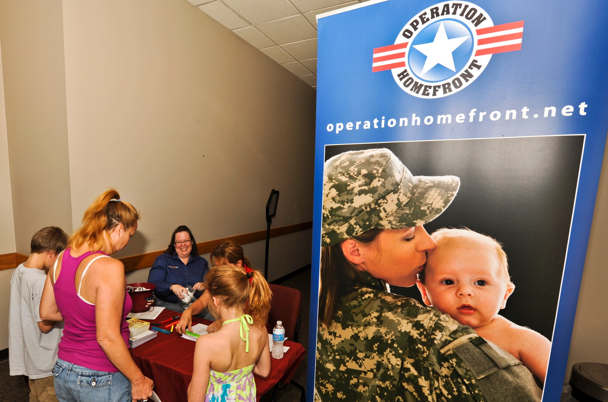 BUCKLEY AIR FORCE BASE, Colo. – A family signs in before they go pick out their backpacks and school supplies, provided by Operation Homefront, Aug. 3, 2012. Students were allowed to take one backpack filled with school supplies. (Air Force photo by Senior Airman Christopher Gross)  