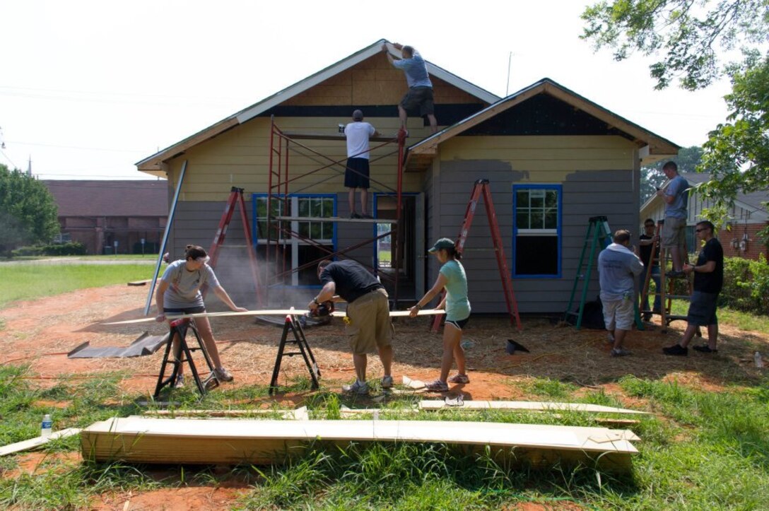 Students from Maxwell's Squadron Officer School class 12D volunteer rebuilding a home in the Montgomery Habitat for Humanity New Hope Village, July 14. For the last month, more than 190 students from the class have worked to restore the house that was destroyed by fire in April. (Courtesy photo) 