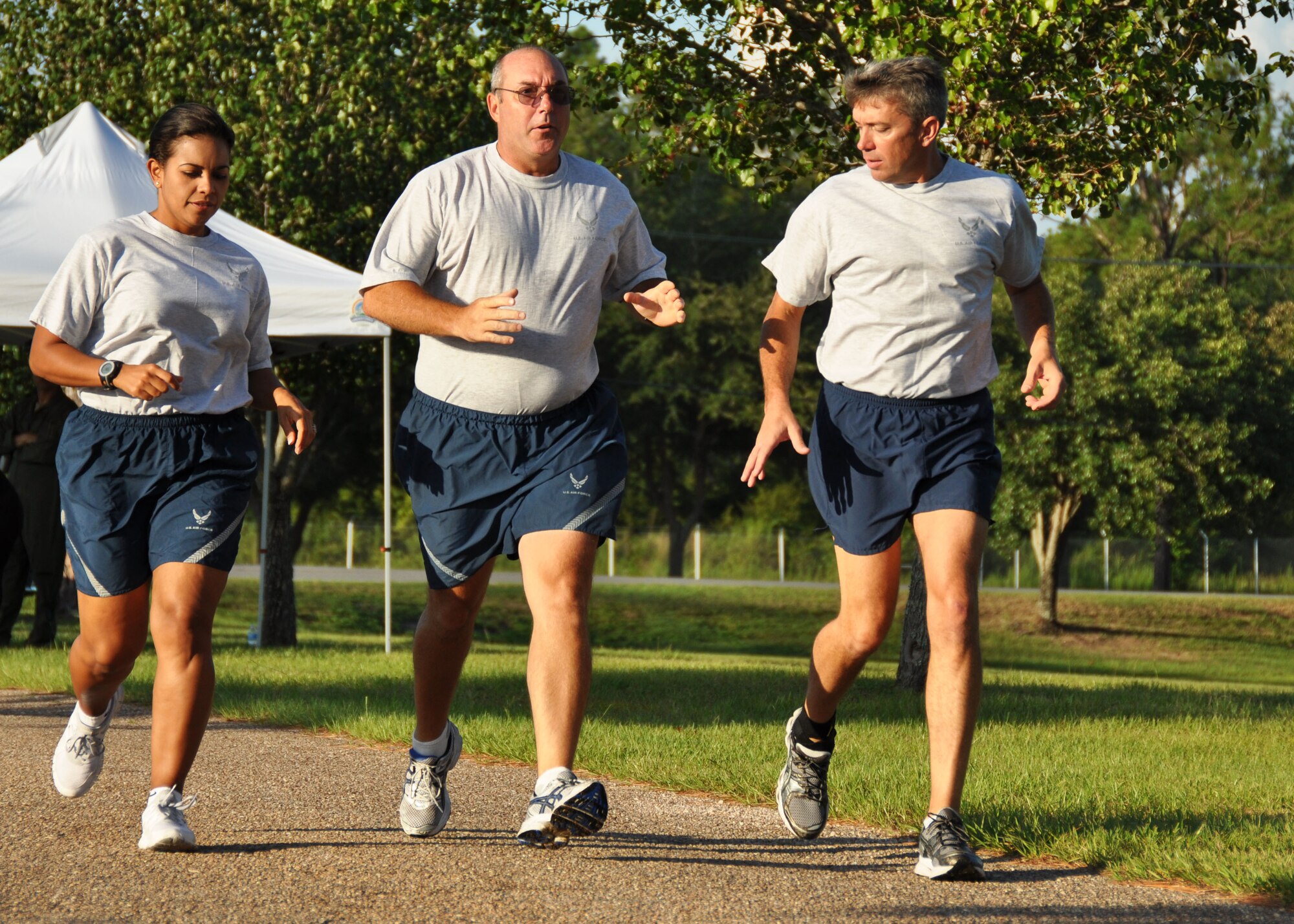 Flanked by Running Clinic leaders 2nd Lieutenant Dalia Delannoy, 919th Mission Support Group, and Master Sgt. Dan Landrum, 919th Security Forces Squadron, Senior Master Sgt. William Goodman, 919th Maintenance Squadron, receives tips on optimal running stride and pacing during a recent Fit-to-Fight training run at Duke Field, Fla.  The program gives Airmen the tools they need to improve the way they train for and complete the running portion of their Fit-to-Fight tests. (U.S. Air Force photo/Dan Neely)