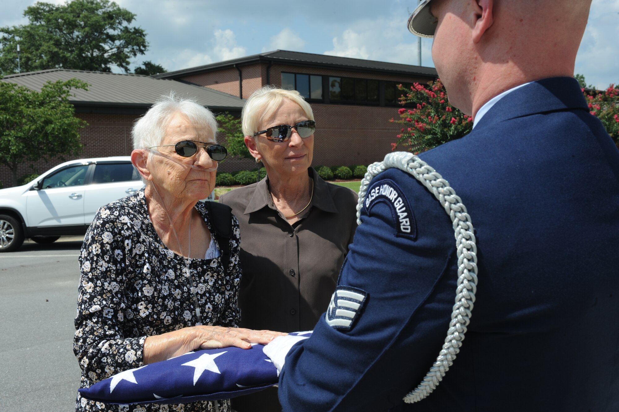 Marilou Mercer accepts an American flag from U.S. Air Force Staff Sgt. Frederick Burke, 4th Fighter Wing honor guardsman, after a flag-folding ceremony on Seymour Johnson Air Force Base, N.C., July 31, 2012. Marilou received the flag in honor of her late husband U.S. Navy Chief Petty Officer retired, Walter Mercer. (U.S. Air Force photo/Airman 1st Class John Nieves Camacho/Released)