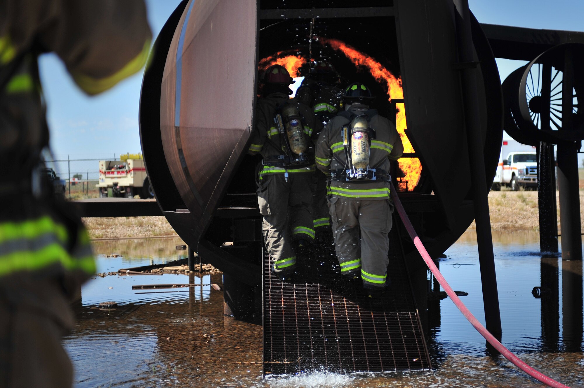 Firefighters with the Clovis, N.M. Fire Department enter the burn pit aircraft to extinguish a fire at Cannon Air Force Base, N.M., Aug. 2, 2012. The pit houses a replicated aircraft equipped with a propane tank and several igniters used to sustain training fires. (U.S. Air Force photo/Airman 1st Class Alexxis Pons Abascal) 
