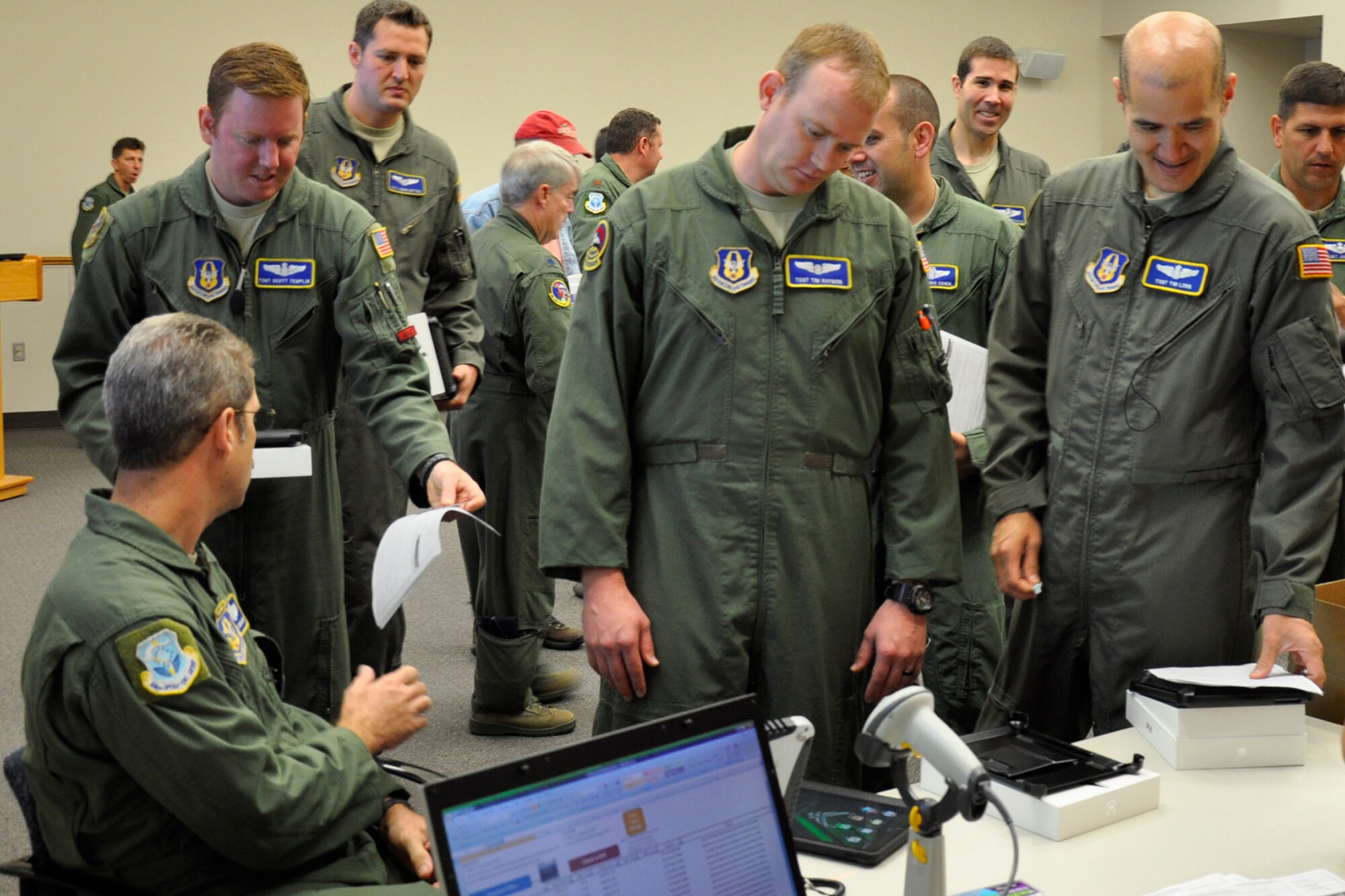 Reserve pilots and loadmasters from the 446th Airlift Wing, McChord Field, Wash., wait to receive their Apple iPad 3 tablets in the 446th Operations Group auditorium here, Aug 3, 2012. Air Mobility Command purchased almost 300 iPads for wing aircrews and they will eventually serve as their primary tool for information access during C-17 Globemaster III missions once the crews have been trained on them. (U.S. Air Force photo/Master Sgt. Jake Chappelle)
