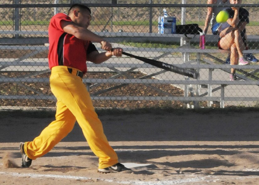 Airman 1st Class Rico Castro, 90th Civil Engineer Squadron firefighter, connects with the softball during the intramural softball tournament on one of F. E. Warren’s ball fields July 19. After his hit, he made it to second base before players from the 90th Security Forces Group tactical response force were able to field the ball and hold him. (U.S. Air Force photo by Airman 1st Class Jason Wiese)