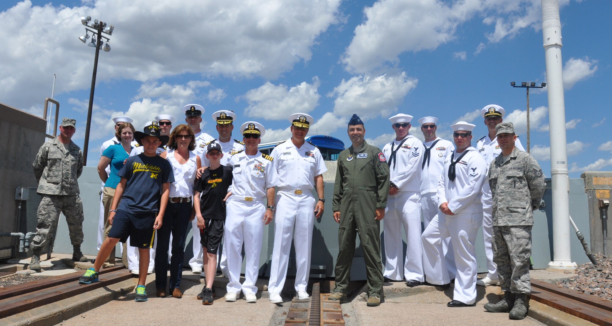 Navy Rear Adm. Douglas Asbjornsen, Navy Northwest Region deputy commander, and Col. George Farfour, 90th Missile Wing vice commander, pose with the crew of the USS Wyoming, and family members, during a base tour July 26 on F. E. Warren Air Force Base, Wyo. The tour included visits to the 90th Operations Group, the missile procedures trainer and the launch facility trainer. (U.S. Air Force photo by Senior Airman Dan Gage) 
