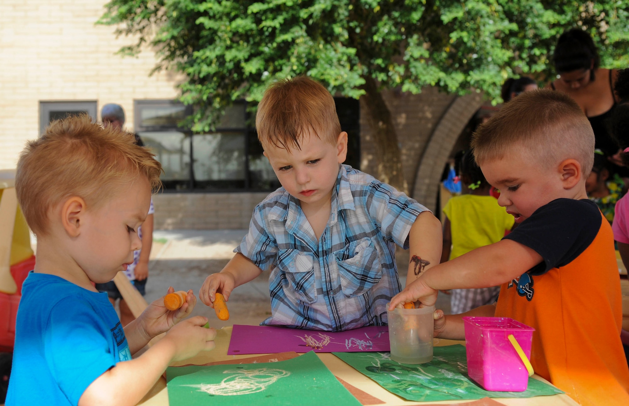 Children ages 2 and 3 draw with chalk in the outdoor play area. There are four classroom age groups: 6 weeks to 1 year, 1 to 2 years, 2 to 3 years and 3 to 5 years. (U.S. Air Force photo by Staff Sgt. Darlene Seltmann)